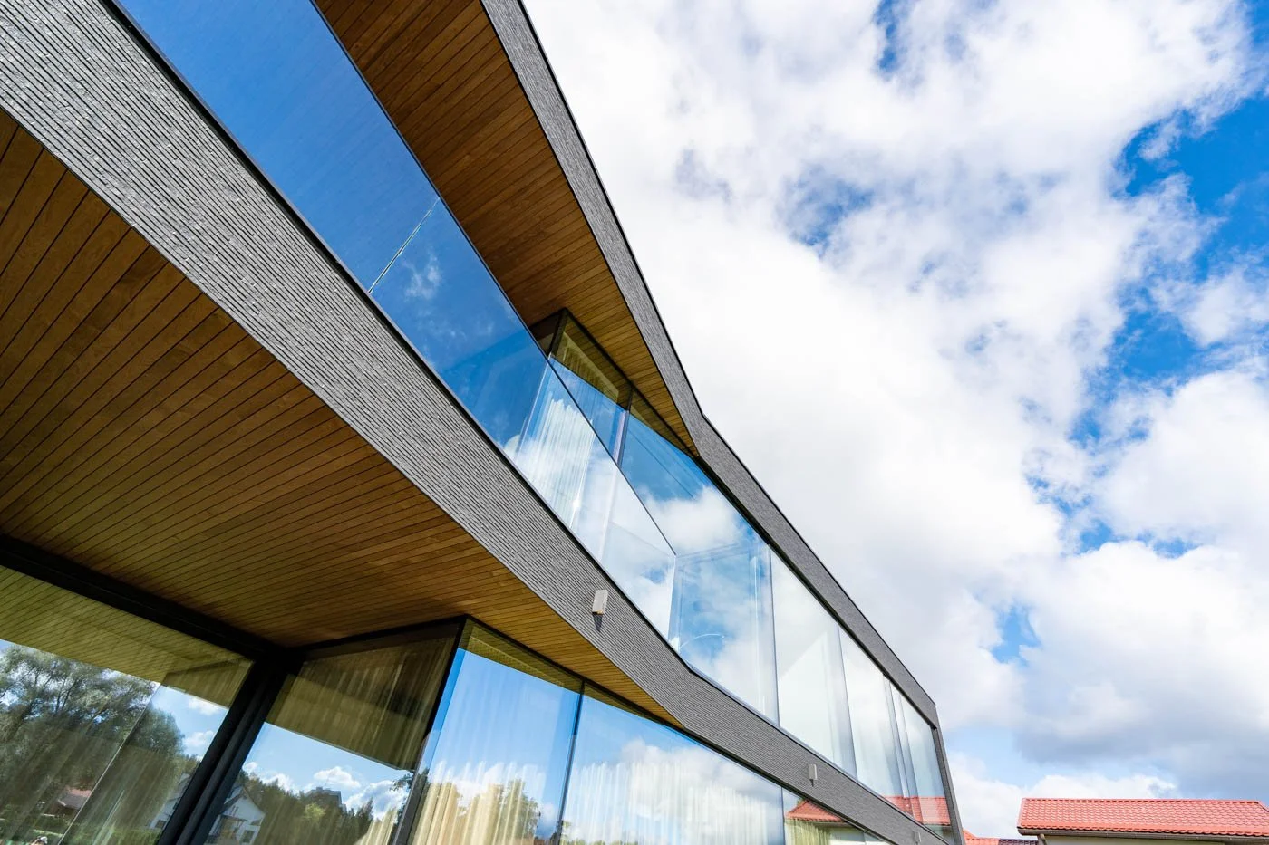 Fasāžu sistēma ar lieliem stiklojumiem modernā privātmājā Bukultos