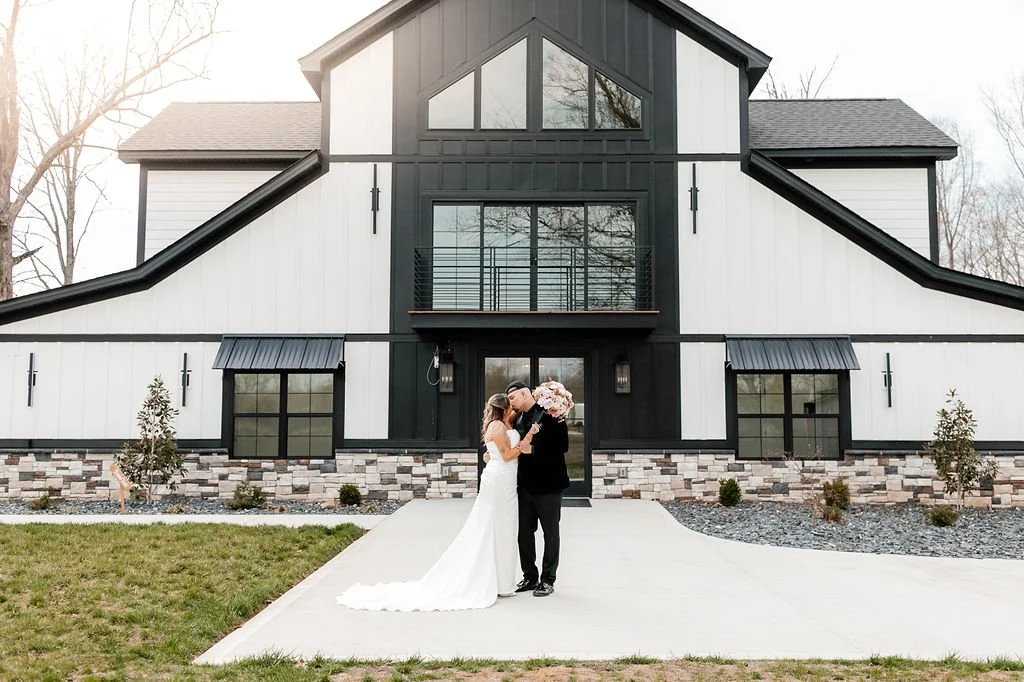 Bride and groom in font of milk and honey farms wedding venue in Chapmansboro, TN