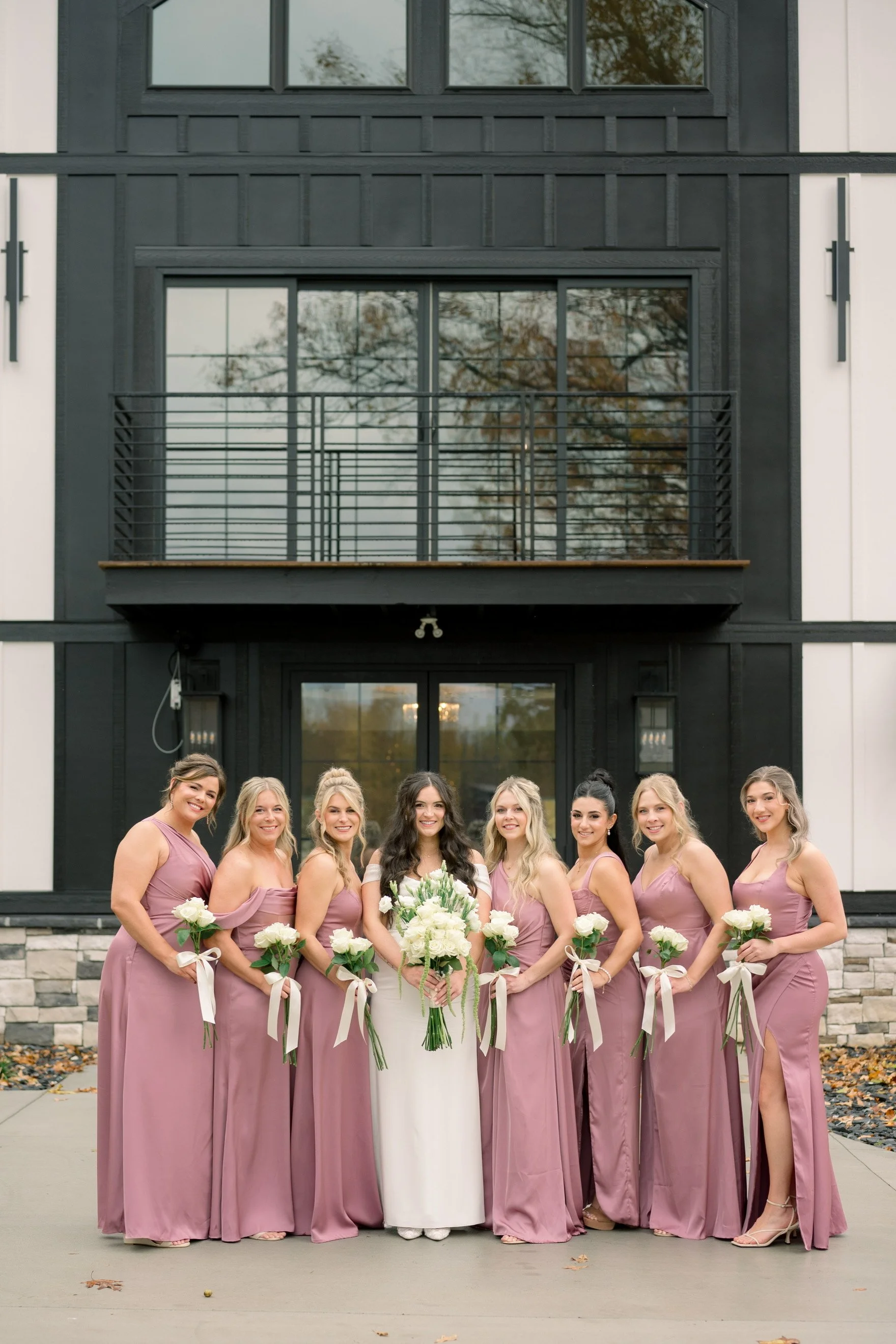 Bride and bridesmaids standing in front of wedding venue milk and honey farms chapmansboro,tn