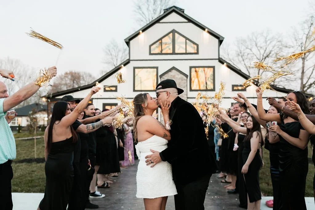 Bride and groom kissing behind wedding venue milk and honey farms