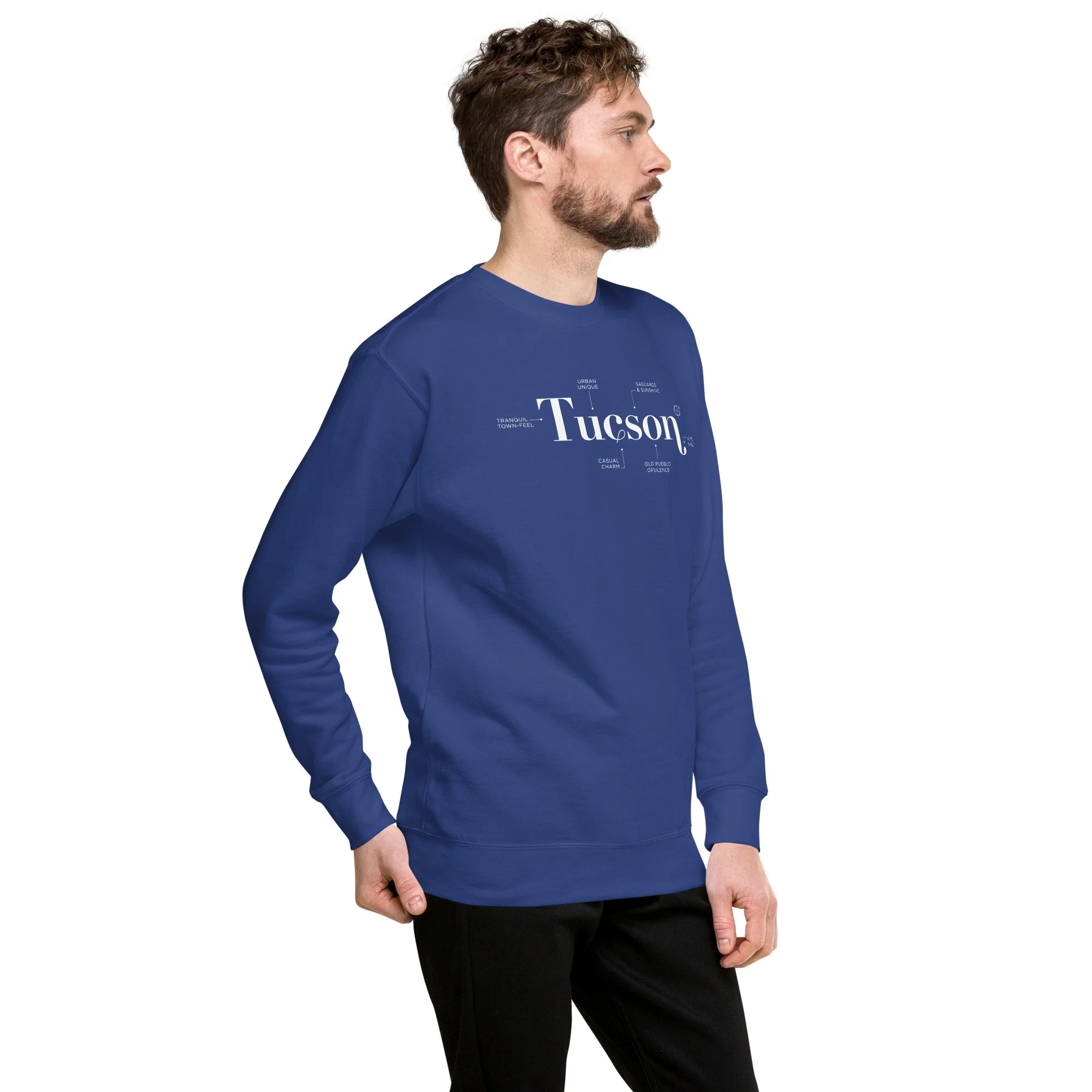 Young man in a unisex, super soft minimalist Tucson Defined graphic Sweatshirt in beautiful Team Royal blue. he perfect fall winter sweater for dressing up or wearing casually.