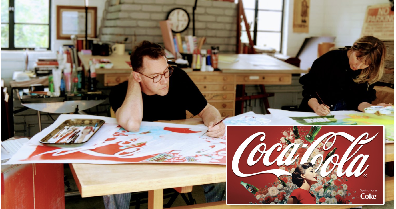 A man with glasses resting his head on his hand at a cluttered table, and a woman writing or painting on a large paper, in a studio with supplies and a clock in the background. There is a red Coca-Cola advertisement with a woman in a red dress and bottles of Coca-Cola in the bottom right corner.