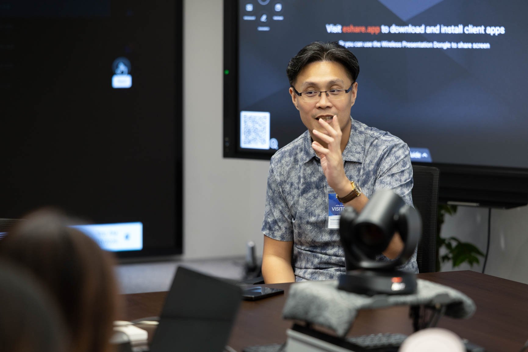 Trainer speaking with participants during an interactive smartphone photography course designed for corporate teams.