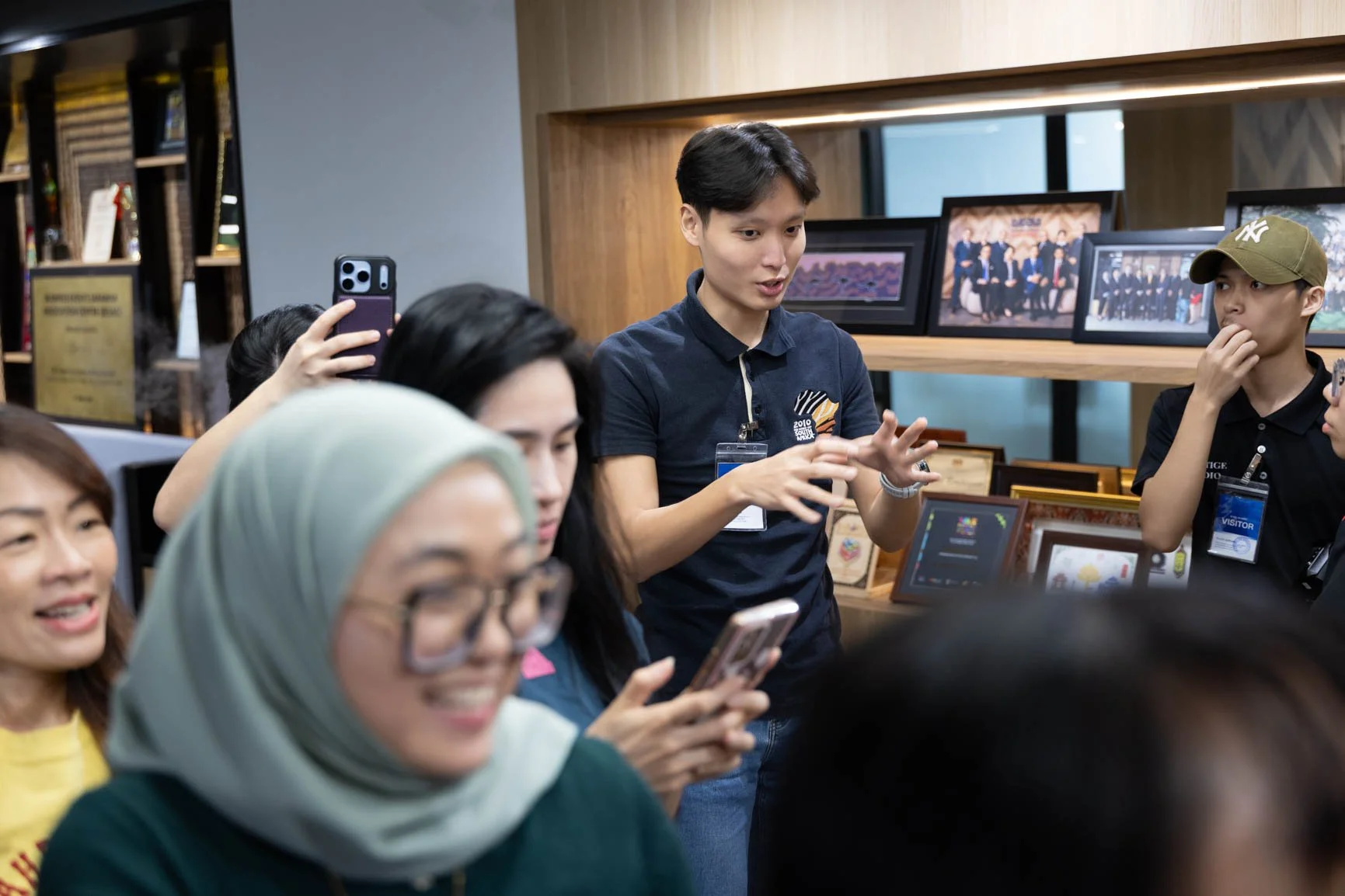 Trainer guiding participants through a hands-on smartphone photography exercise during a corporate workshop in Sarawak.