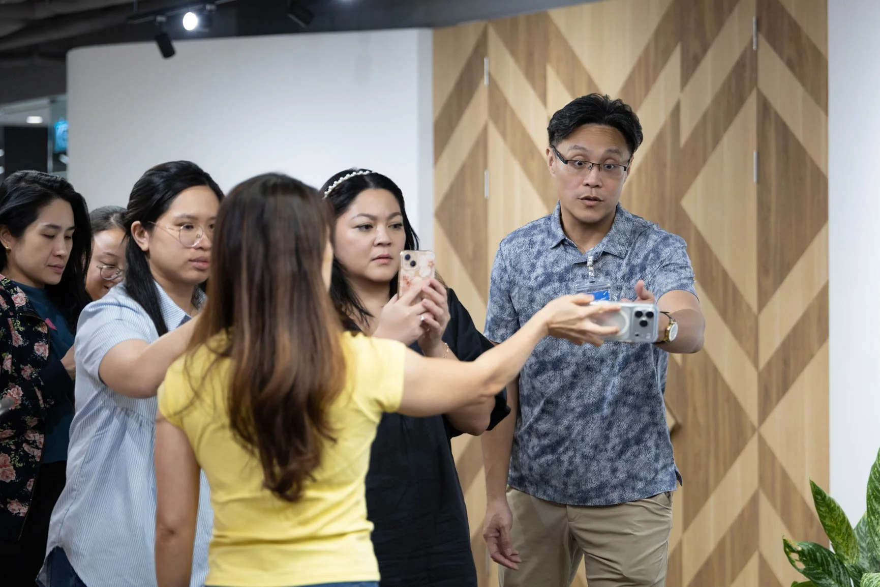 Trainer demonstrating smartphone photography techniques with participants during a hands-on corporate training session.