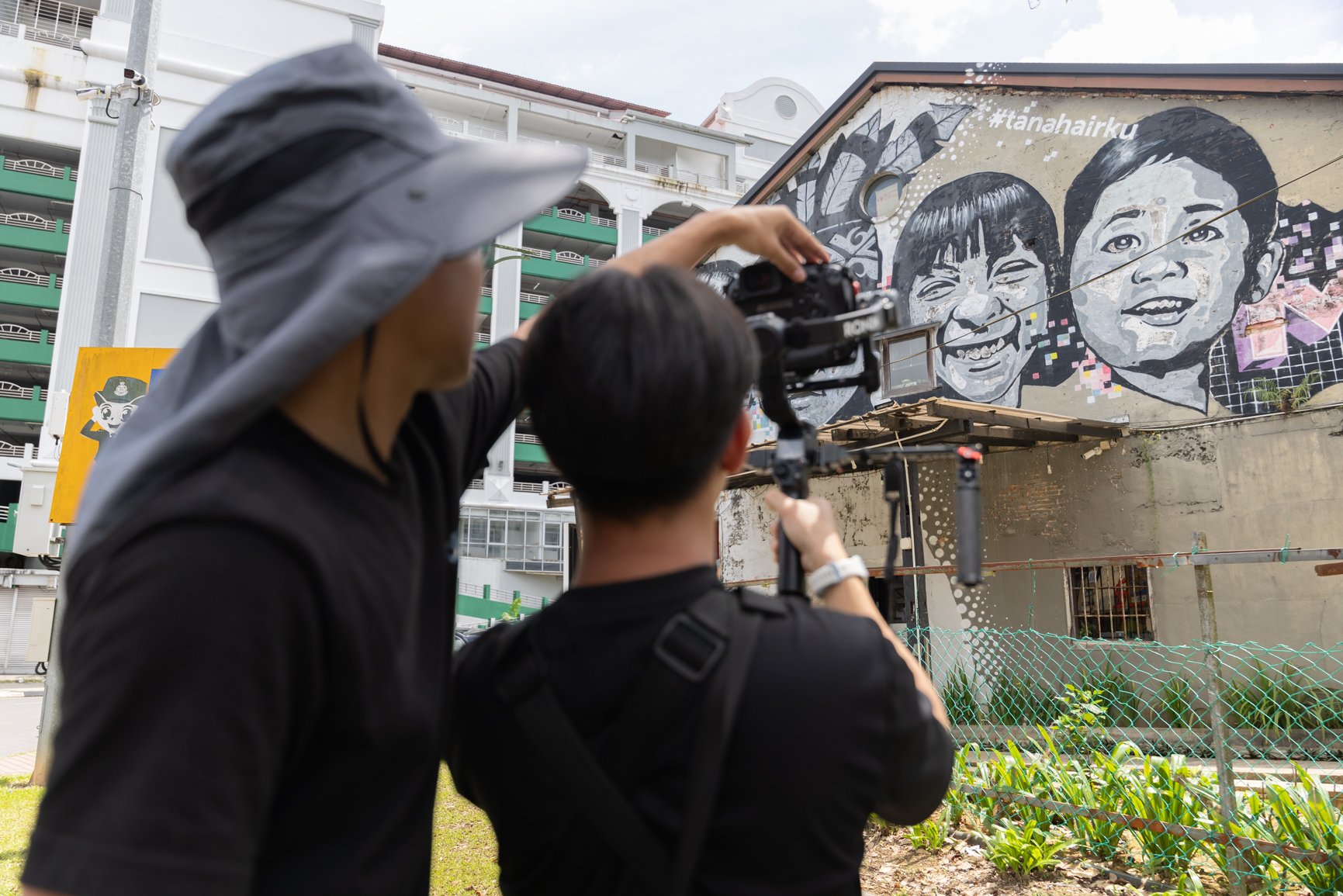 Behind the scenes of a Sarawak Tourism Board commercial shoot with crew filming a street mural in Kuching