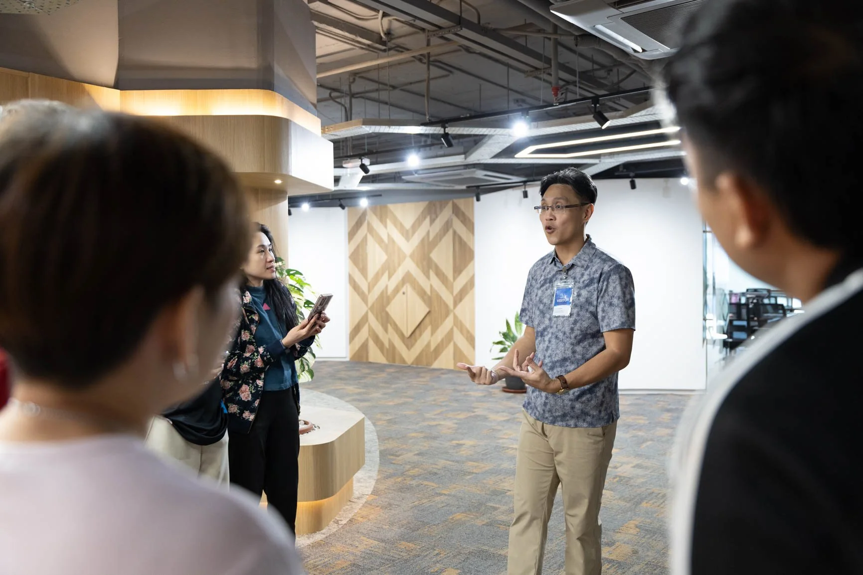 Photography trainer explaining techniques to corporate participants during a practical smartphone photography workshop in Sarawak.