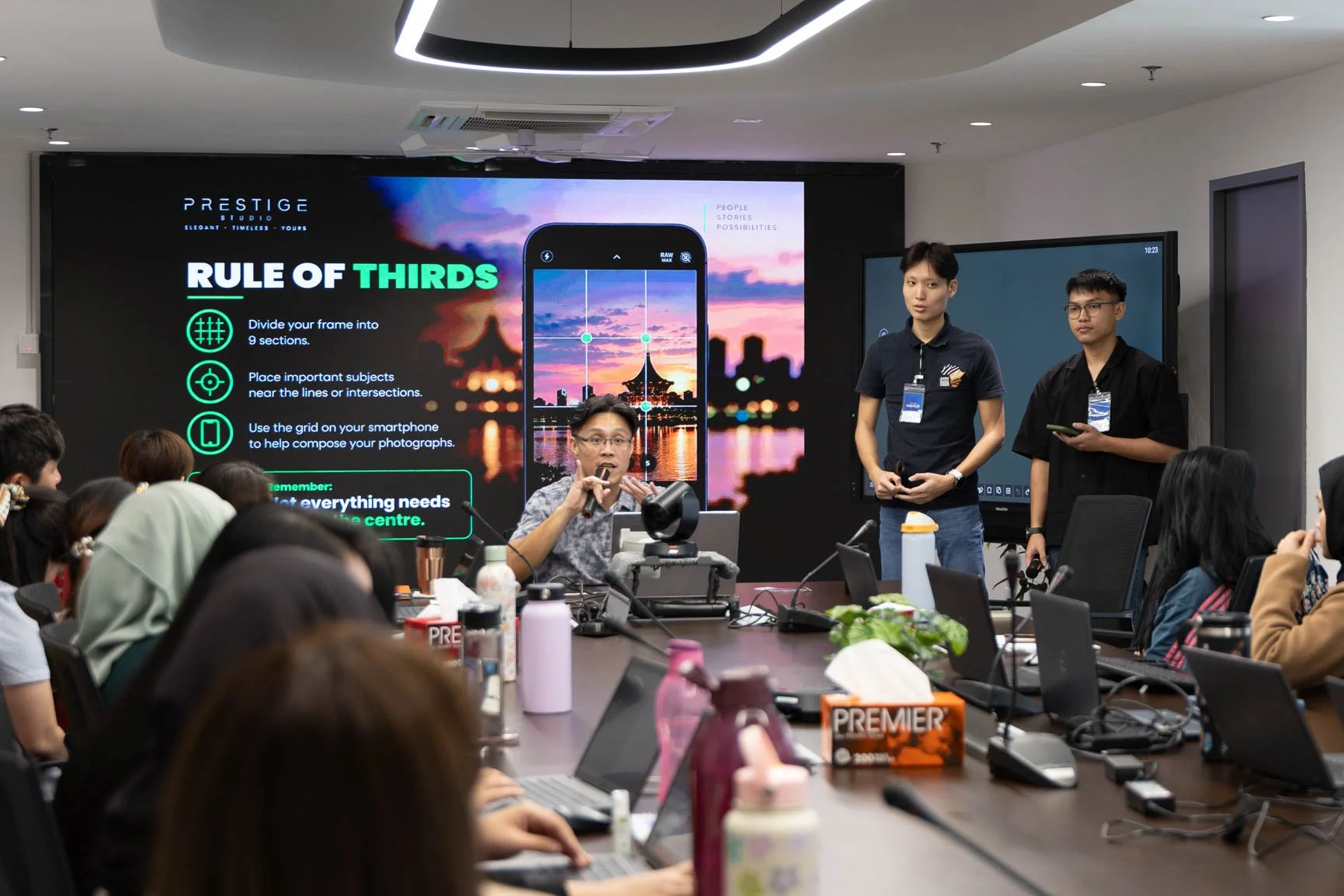 Corporate participants learning the rule of thirds and smartphone photography composition during a practical training session.