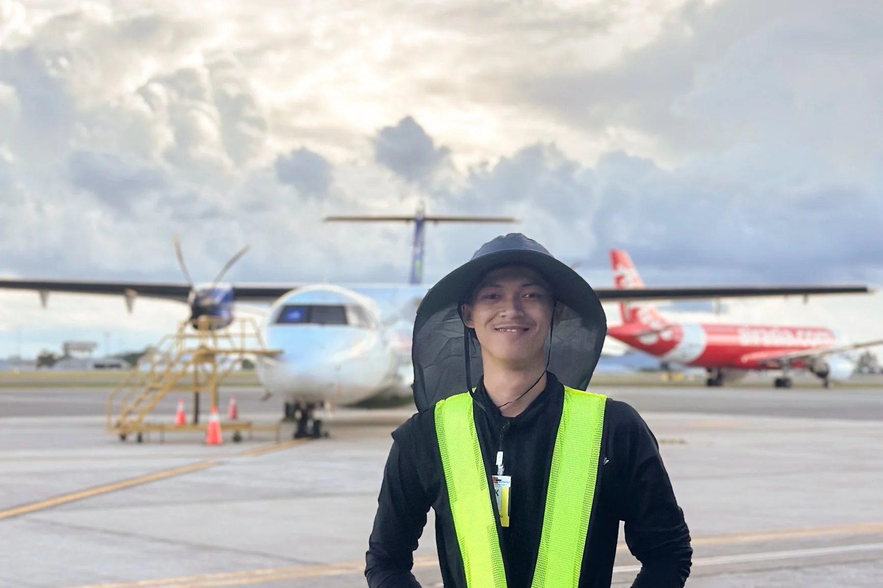 Video production crew member at airport runway during aviation filming project in Sarawak for Air Borneo