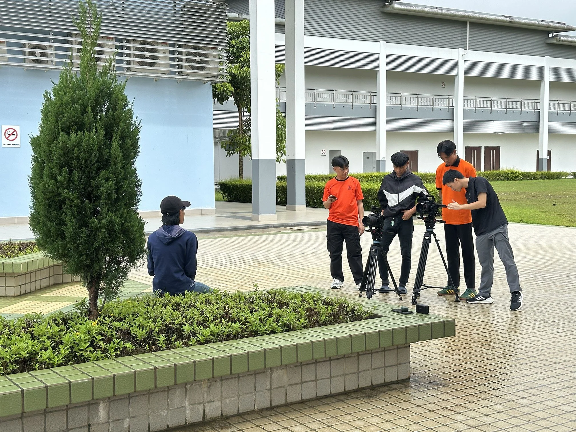 CENTEXS Lundu students practising outdoor interview filming with professional cameras as part of real-world video production training