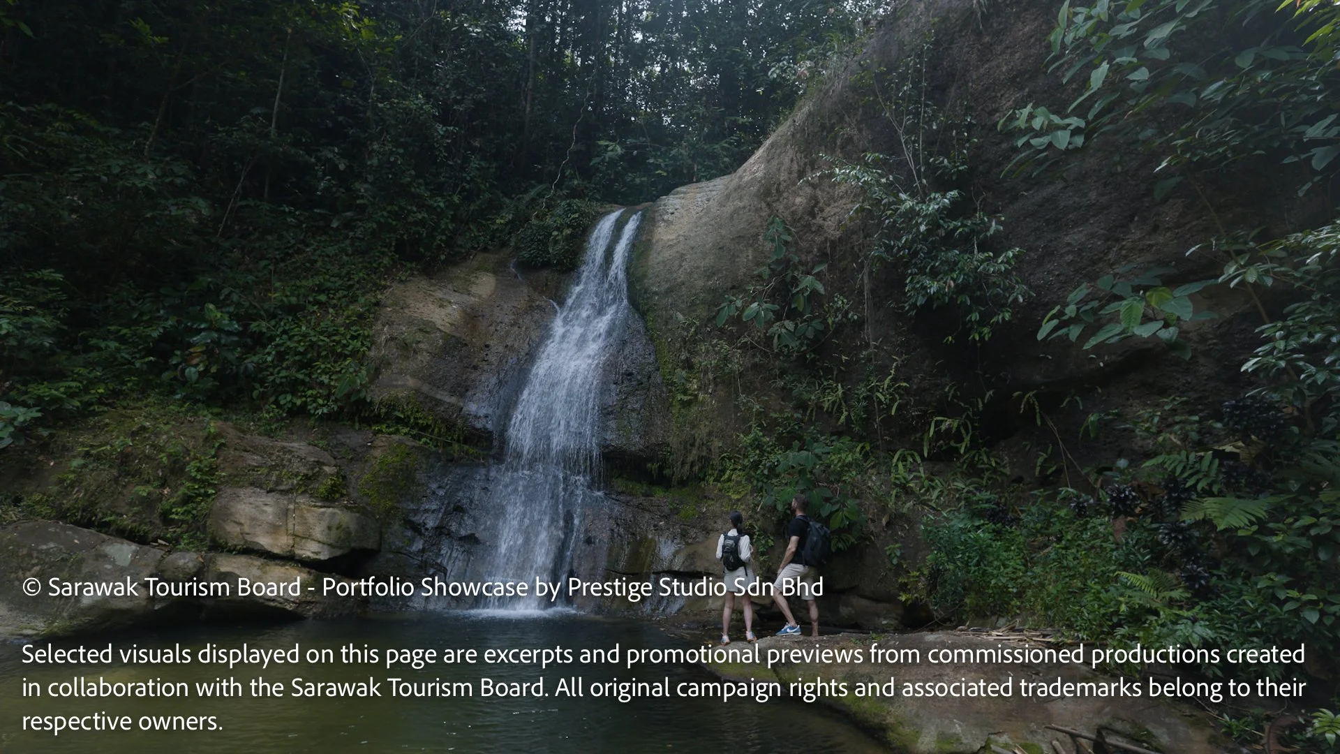 Travellers exploring Ban Buan Kukuot Waterfall in Sarawak rainforest featured in the Gateway to Borneo tourism campaign by Prestige Studio Sdn Bhd.