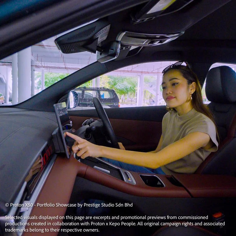 Talent demonstrating the Proton X50 infotainment system inside the vehicle
