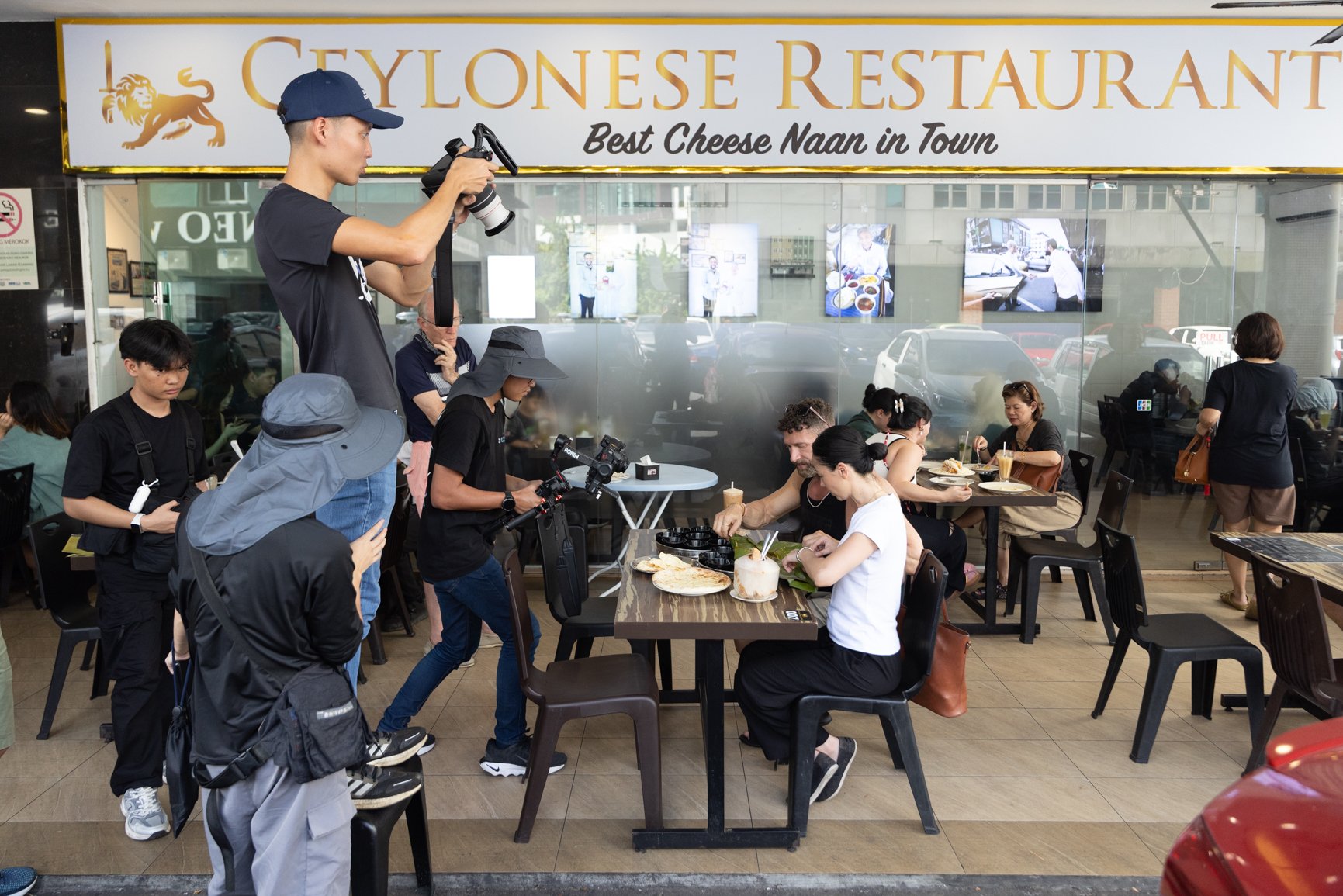 Behind the scenes of a Sarawak Tourism Board commercial shoot with crew filming talents dining at a local restaurant