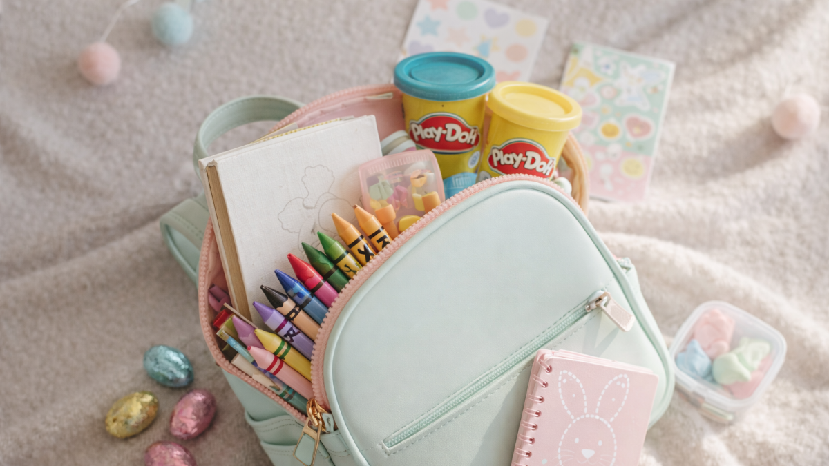 An art-themed Easter basket idea for toddlers using a reusable mini backpack with crayons, stickers, and coloring books.
