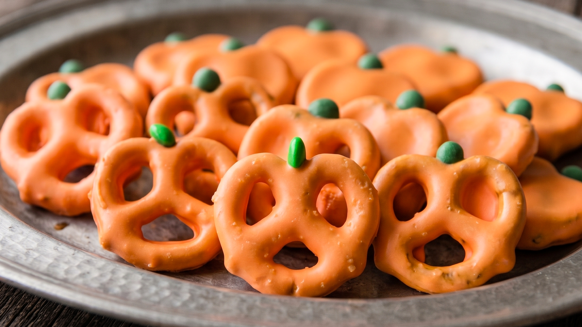 Mini pretzels dipped in candy melts to create a fun treat that looks just like pumpkins for Halloween.