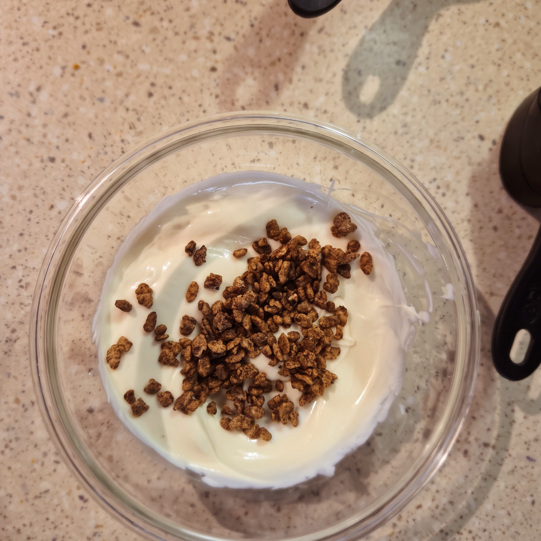 Ingredients for reverse crunch bars being mixed in a clear glass bowl.