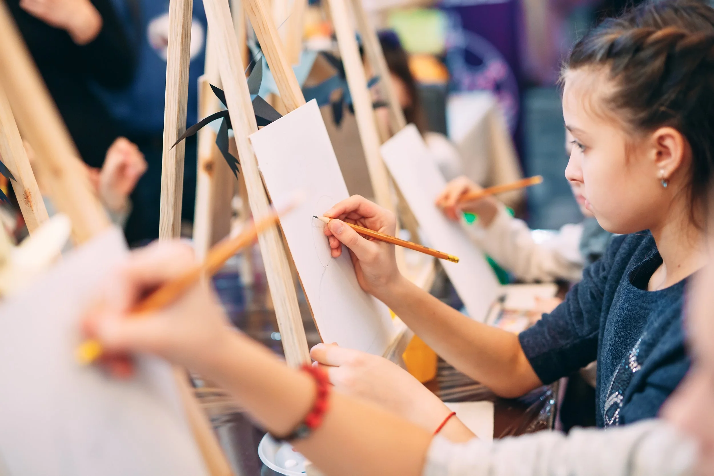 Kids drawing on easels at a painting party