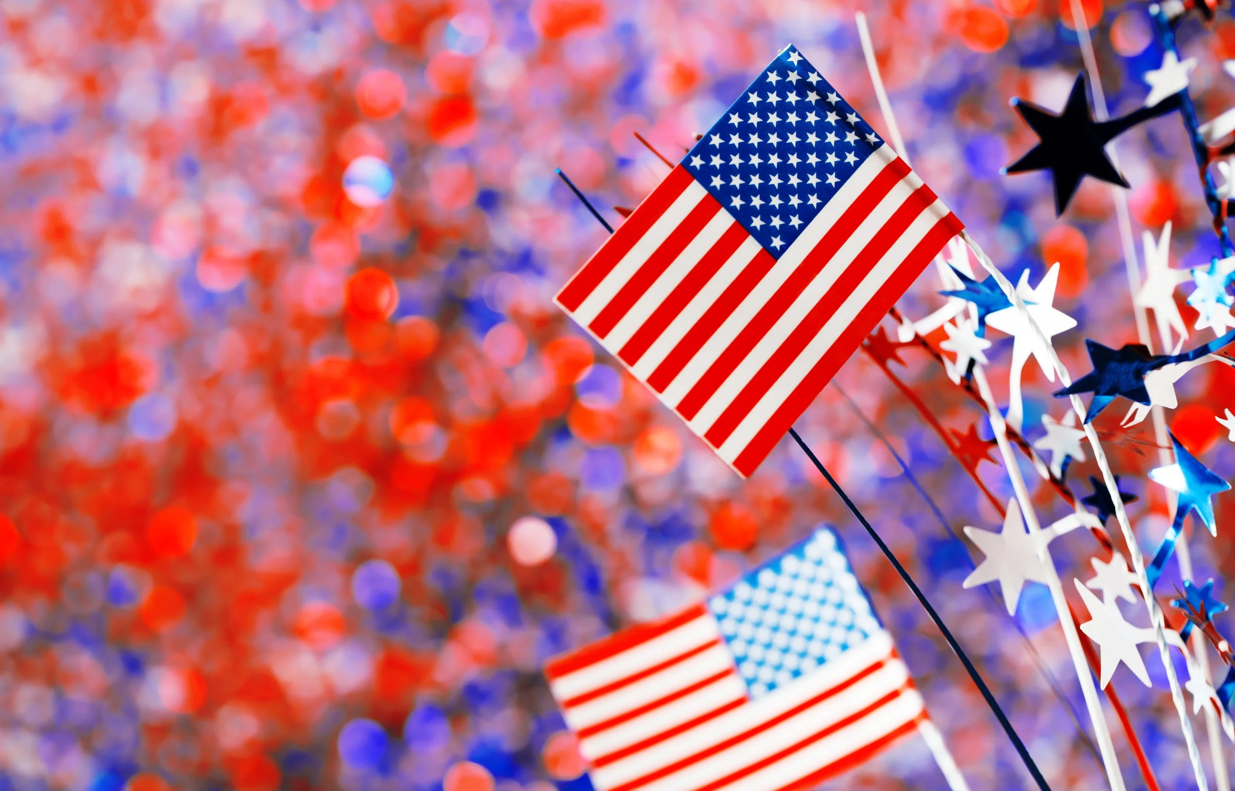 American flags and confetti celebrating July 4th with fun fireworks alternatives that help prevent triggers for PTSD.