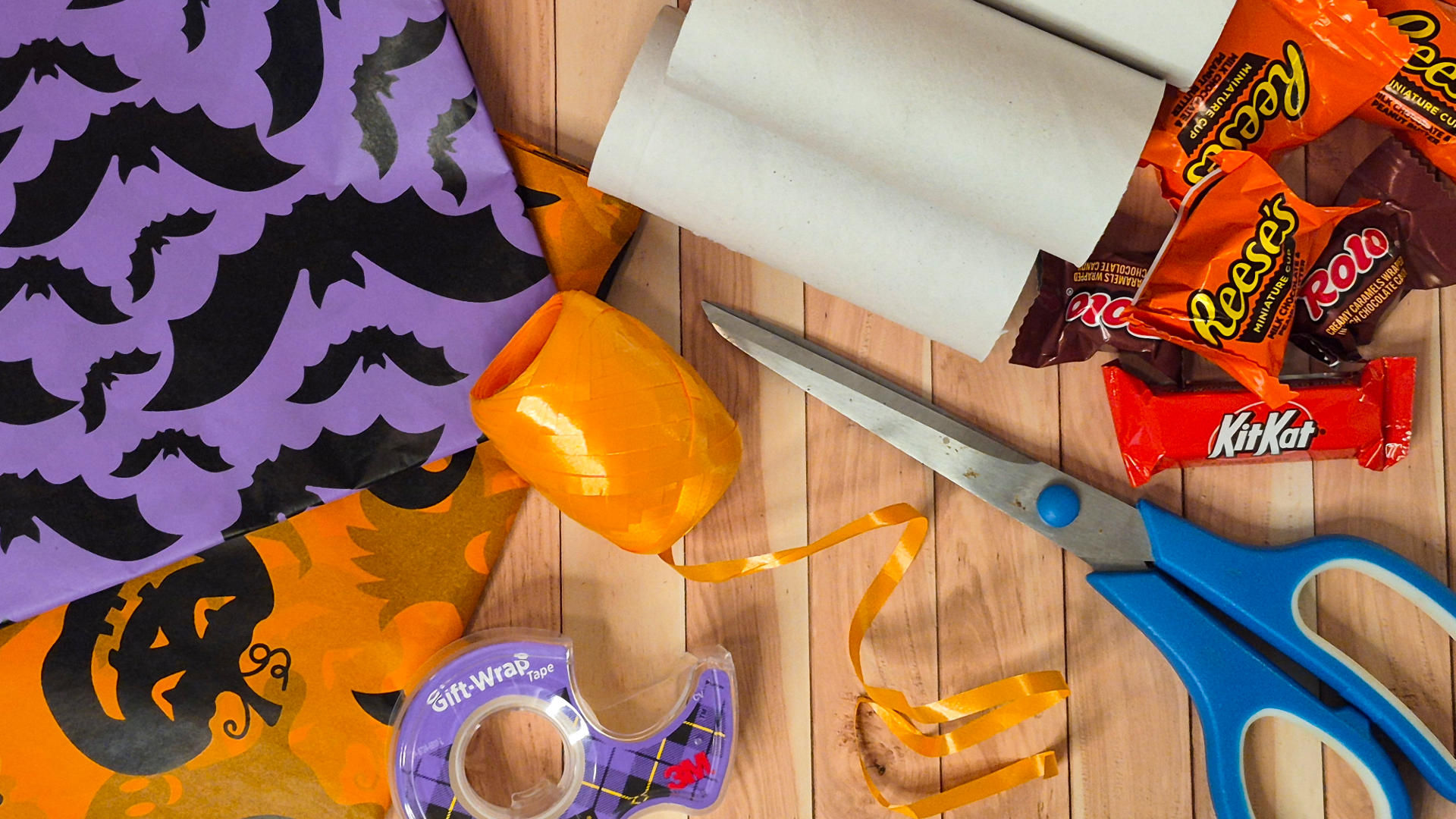 Overhead flat lay of craft supplies needed to make sensory-friendly Halloween favor crackers for kids.