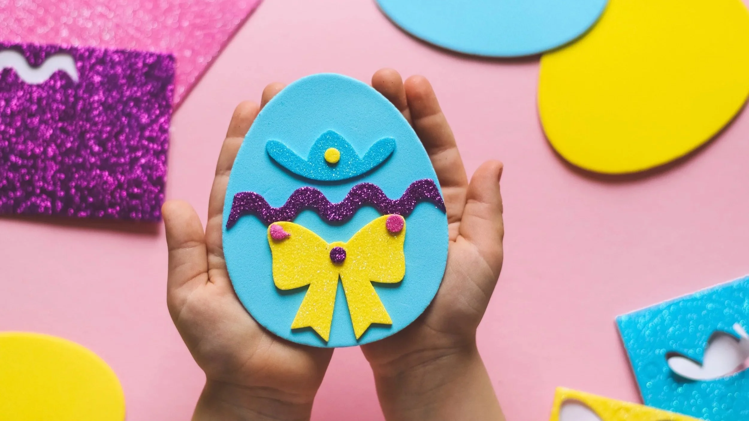 Child holding a colorful foam Easter egg craft as a fun alternative to dyeing Easter eggs