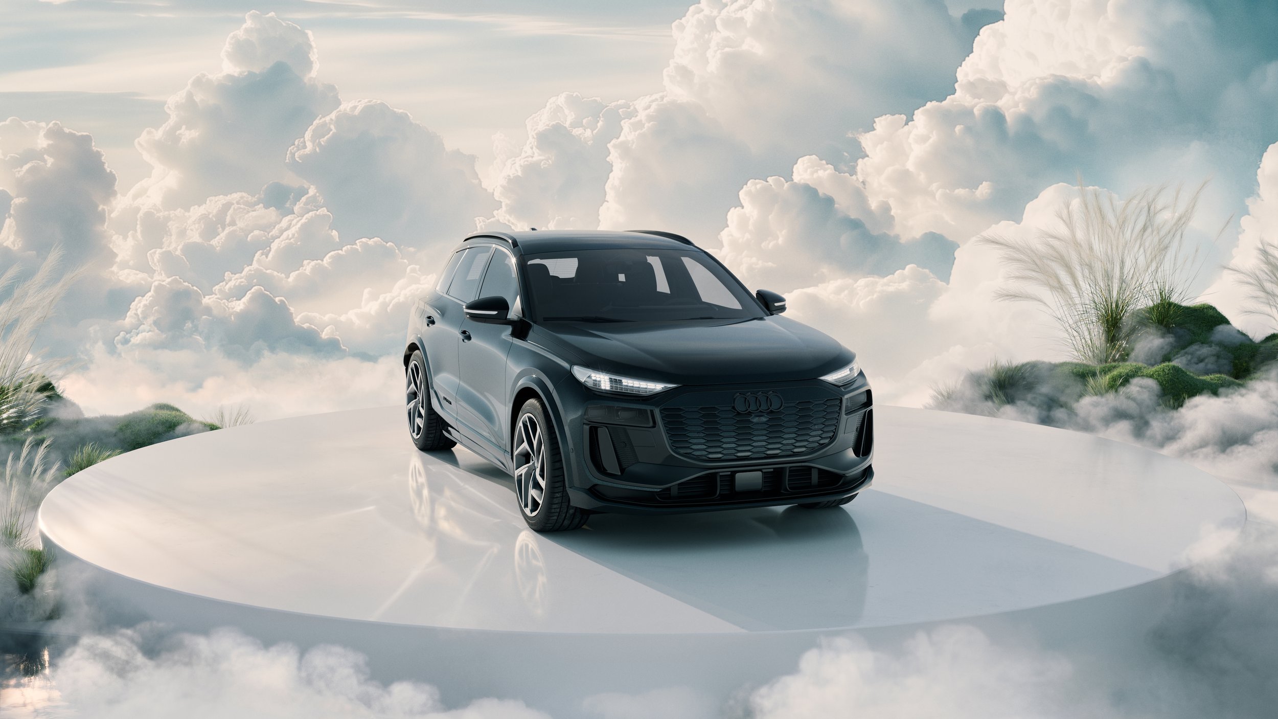 A black Audi SUV displayed on a round white platform with a cloudy sky background and some greenery on the sides.