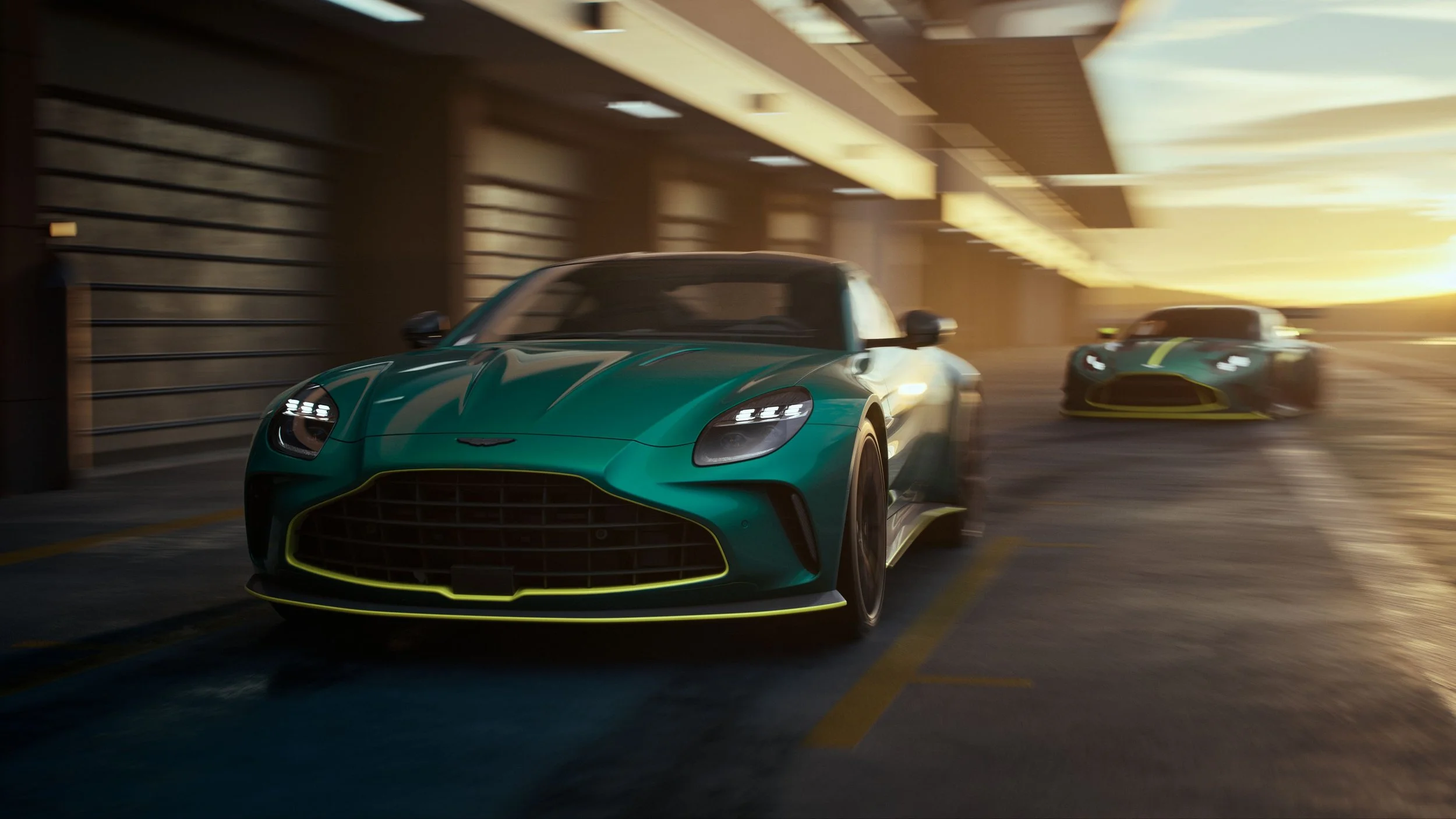 Two sports cars racing through a parking garage with a sunset in the background.