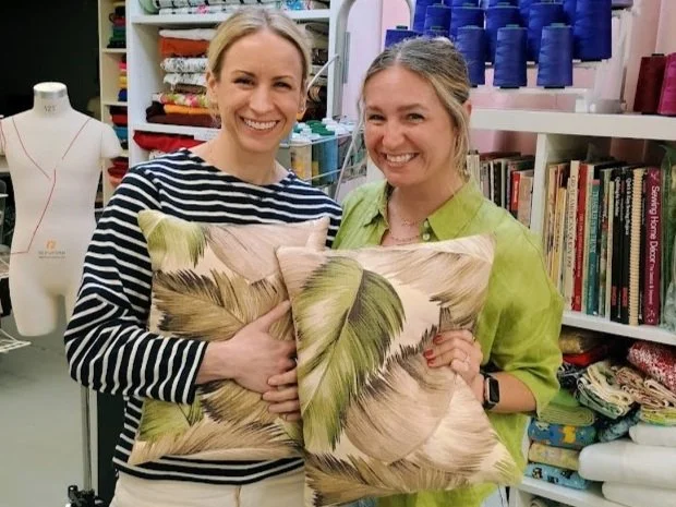 Two makers holding a finished pillow