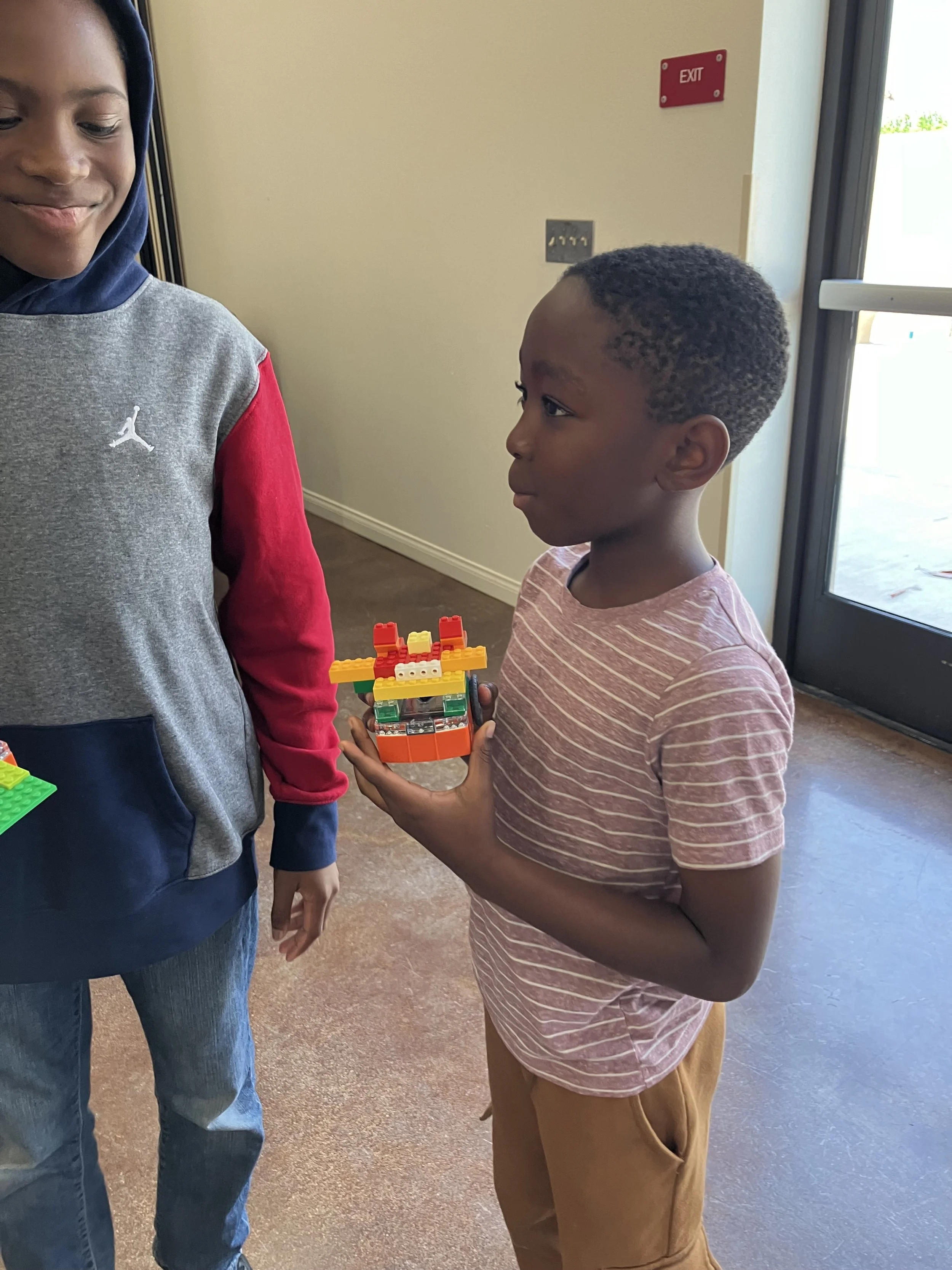 Group of people rehearsing on a dimly lit stage with spotlights overhead.