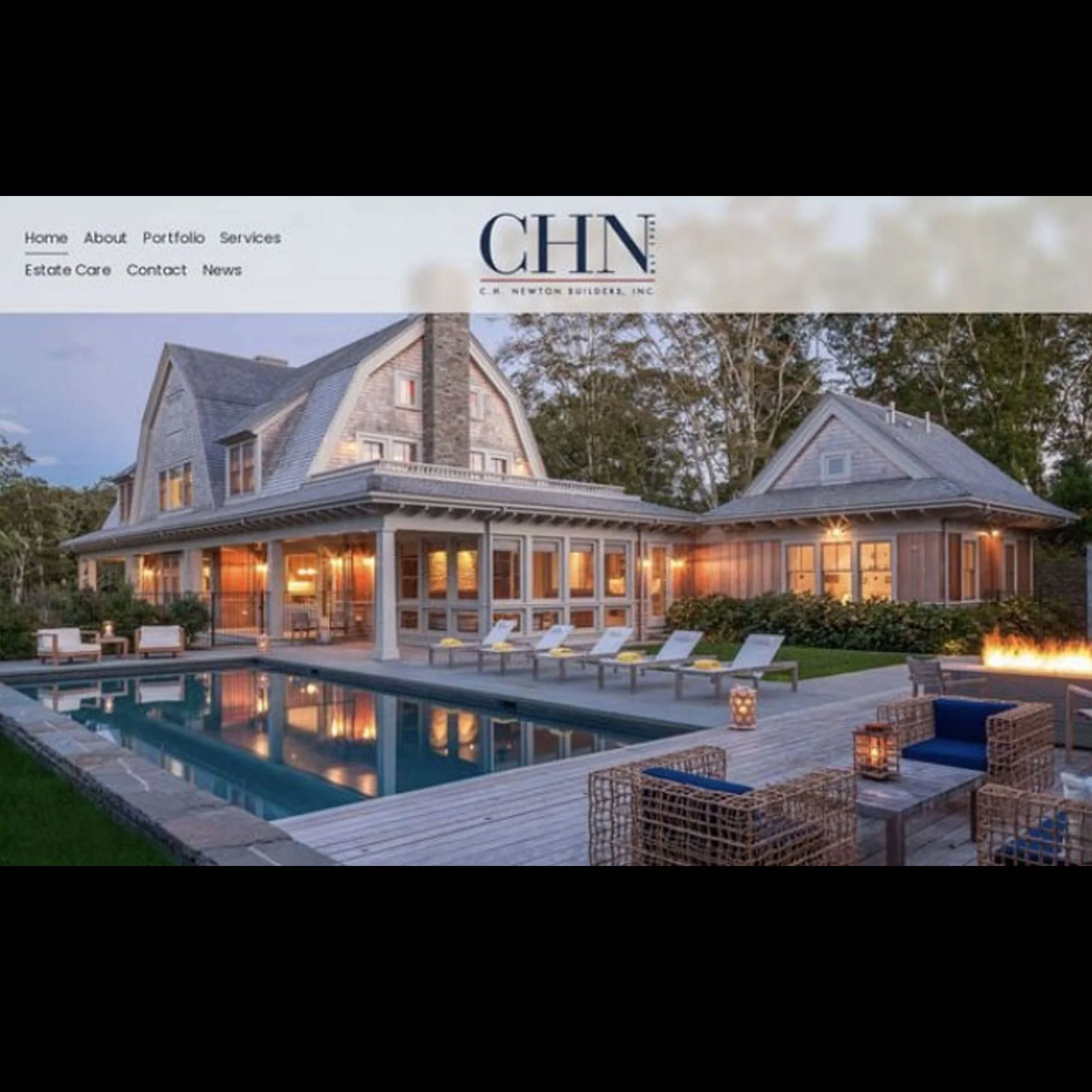 Exterior view of a large house with a swimming pool and outdoor seating area, illuminated by warm lighting at dusk.