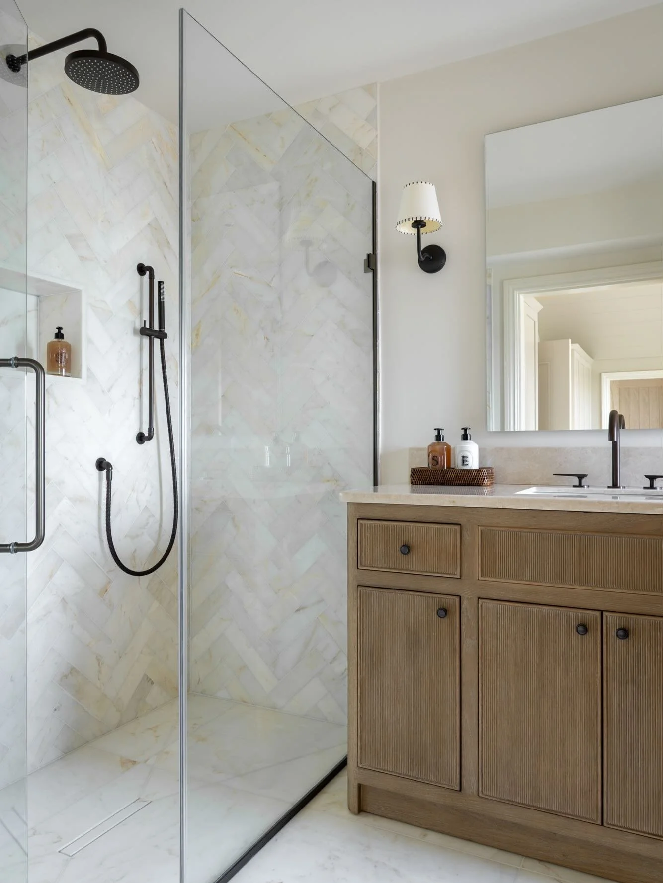 Herringbone marble tiles paired with warm oak joinery &amp; dark hardware... we loved designing every inch of this space! ✨

For this master ensuite, it was all about the textures. Between the quietly elegant marble and the intricate fluted vanity, t