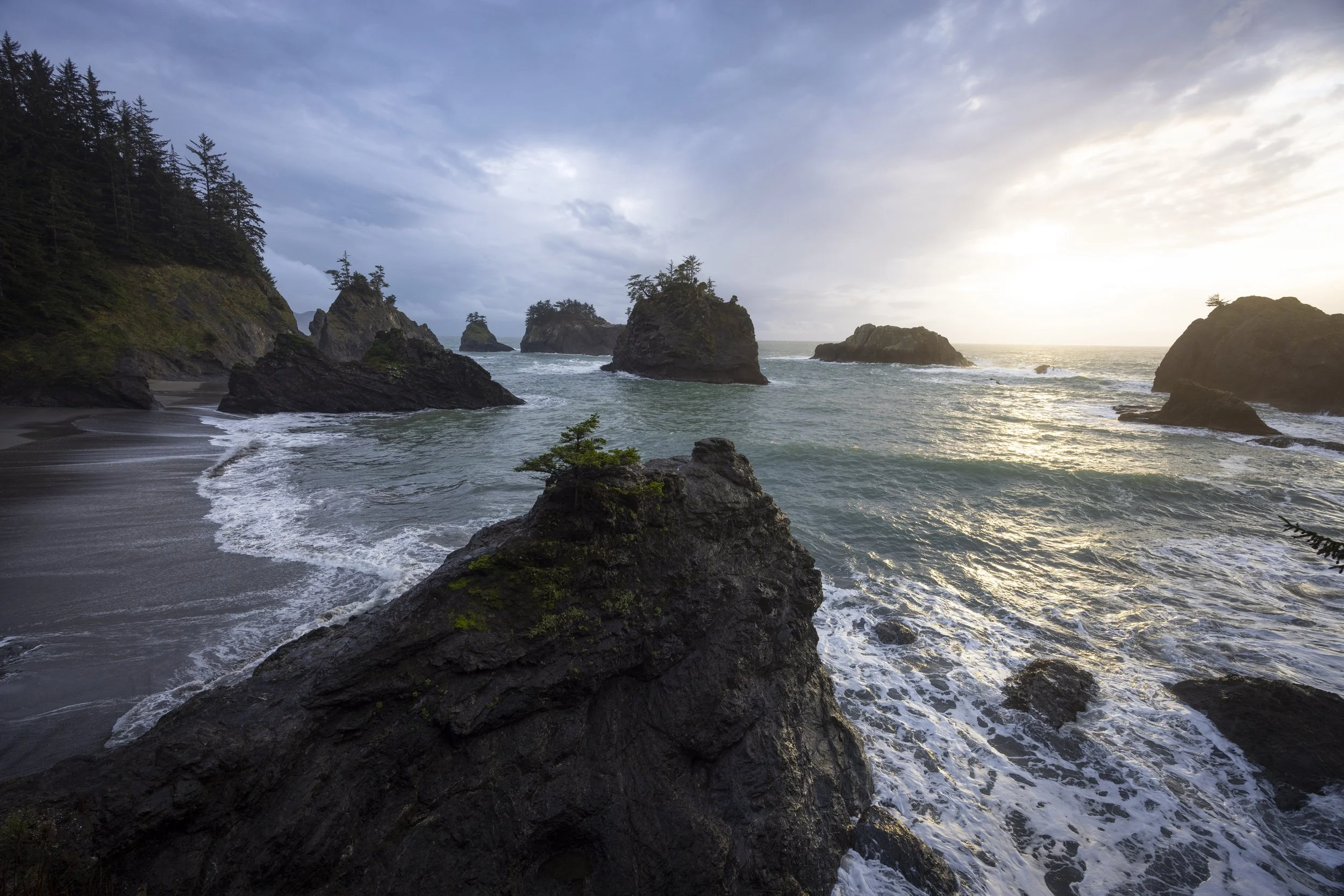 The setting sun pokes out from underneath a passing storm on the southern Oregon coast.