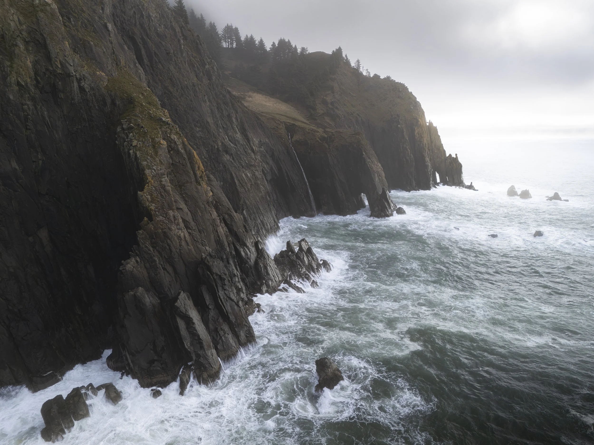 The sun breaks through an early morning storm along the rugged coastline of the Pacific Northwest.