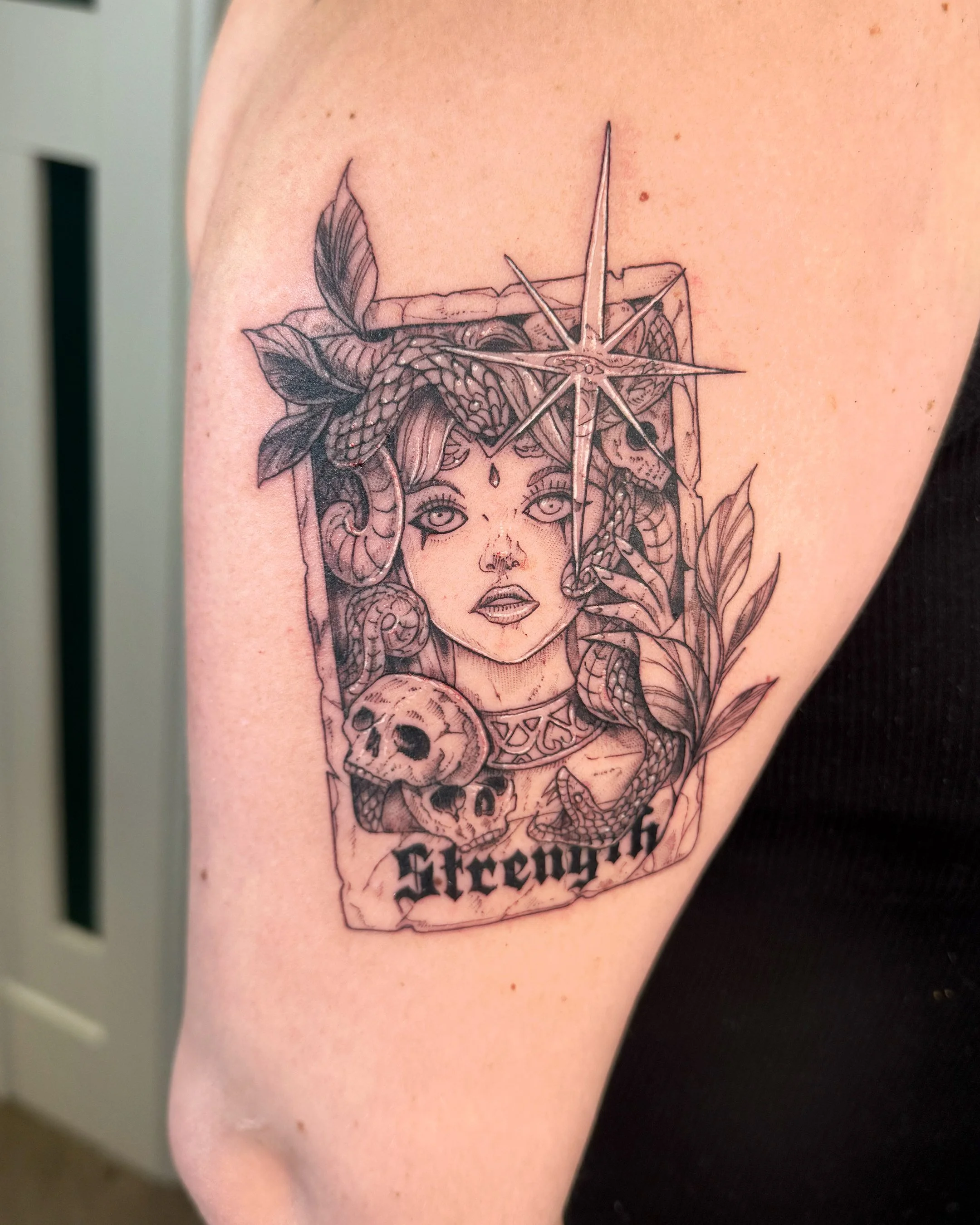 Tattoo of a woman with snakes intertwined with her hair, holding a skull with the words 'Stay Gold' underneath.