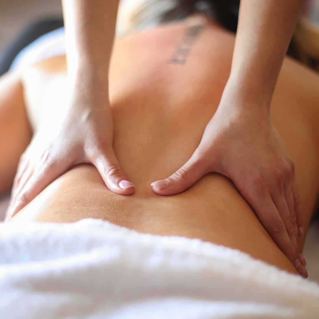 Close-up of a person receiving a back massage with hands pressing on the back and shoulders.