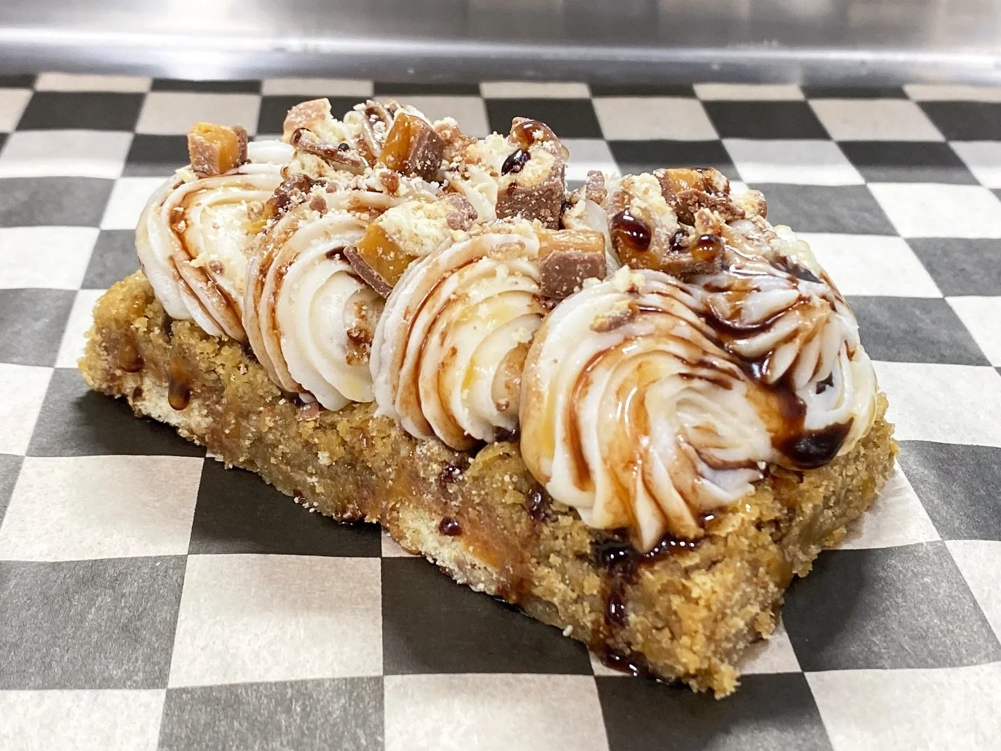 ✨Twix Caramel Blondie✨ Our blondie layered on top of Twix&reg;️ candy bars. Topped with a caramel buttercream, chocolate and caramel drizzle and Twix&reg;️ candy pieces. #blondie #sweets #twix #caramel #chocolate #bakery #foodie #vegas