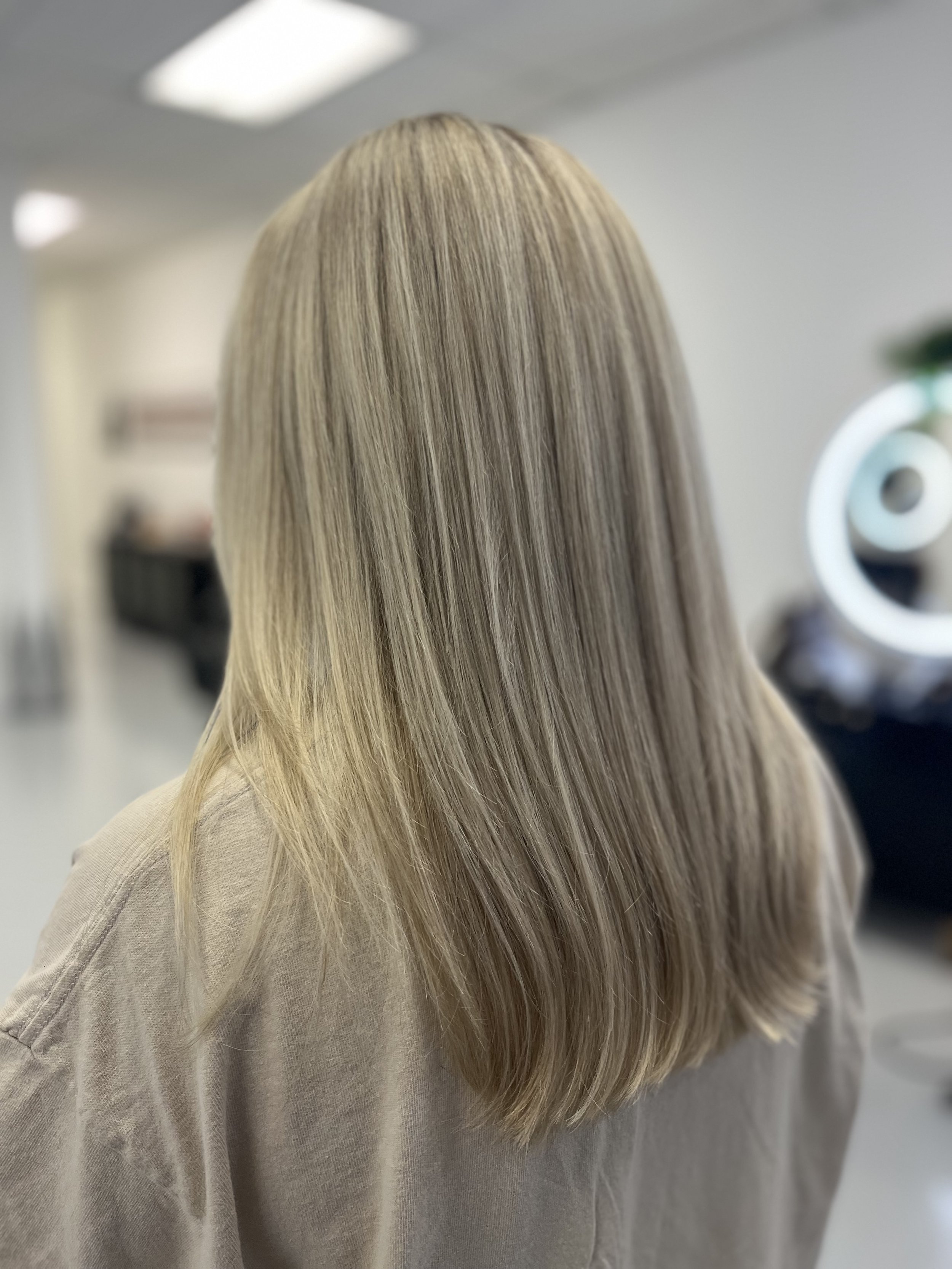 Back view of a woman with long, straight, blonde hair.