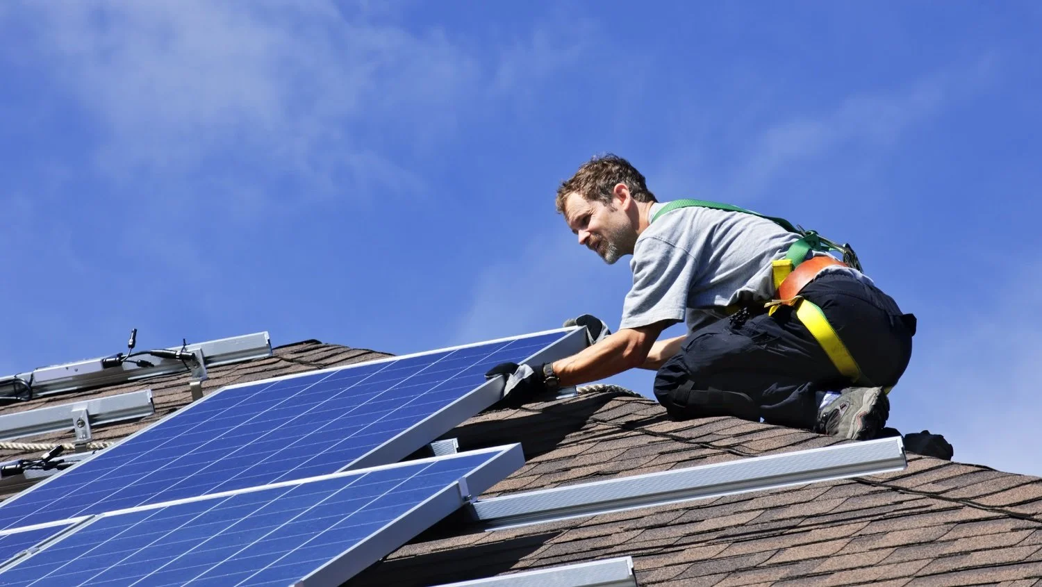 Illinois Solar installer mounting residential rooftop solar panels during a professional solar panel installation.