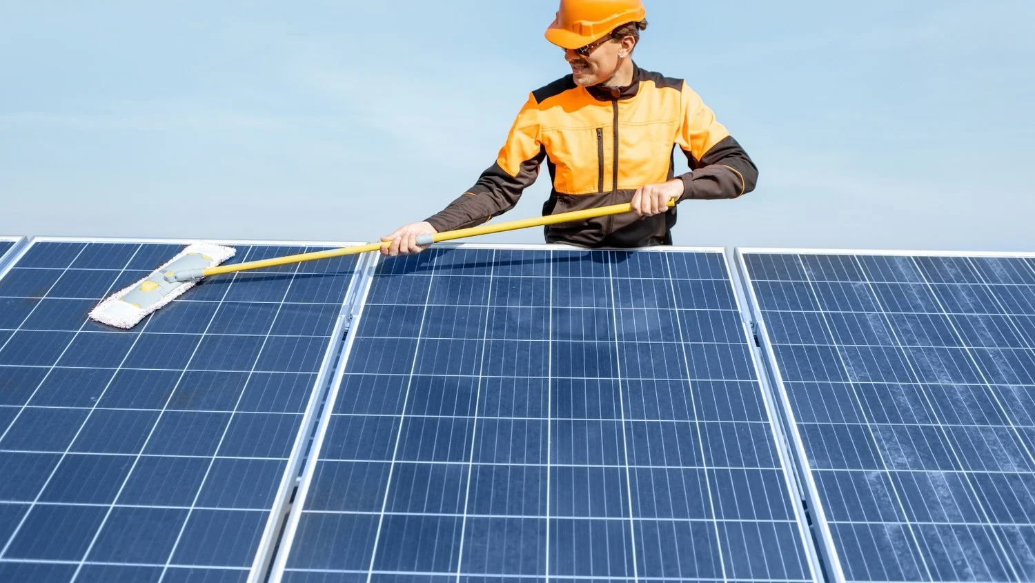 Technician cleaning rooftop solar panels as part of Illinois Solar panel cleaning and maintenance services.