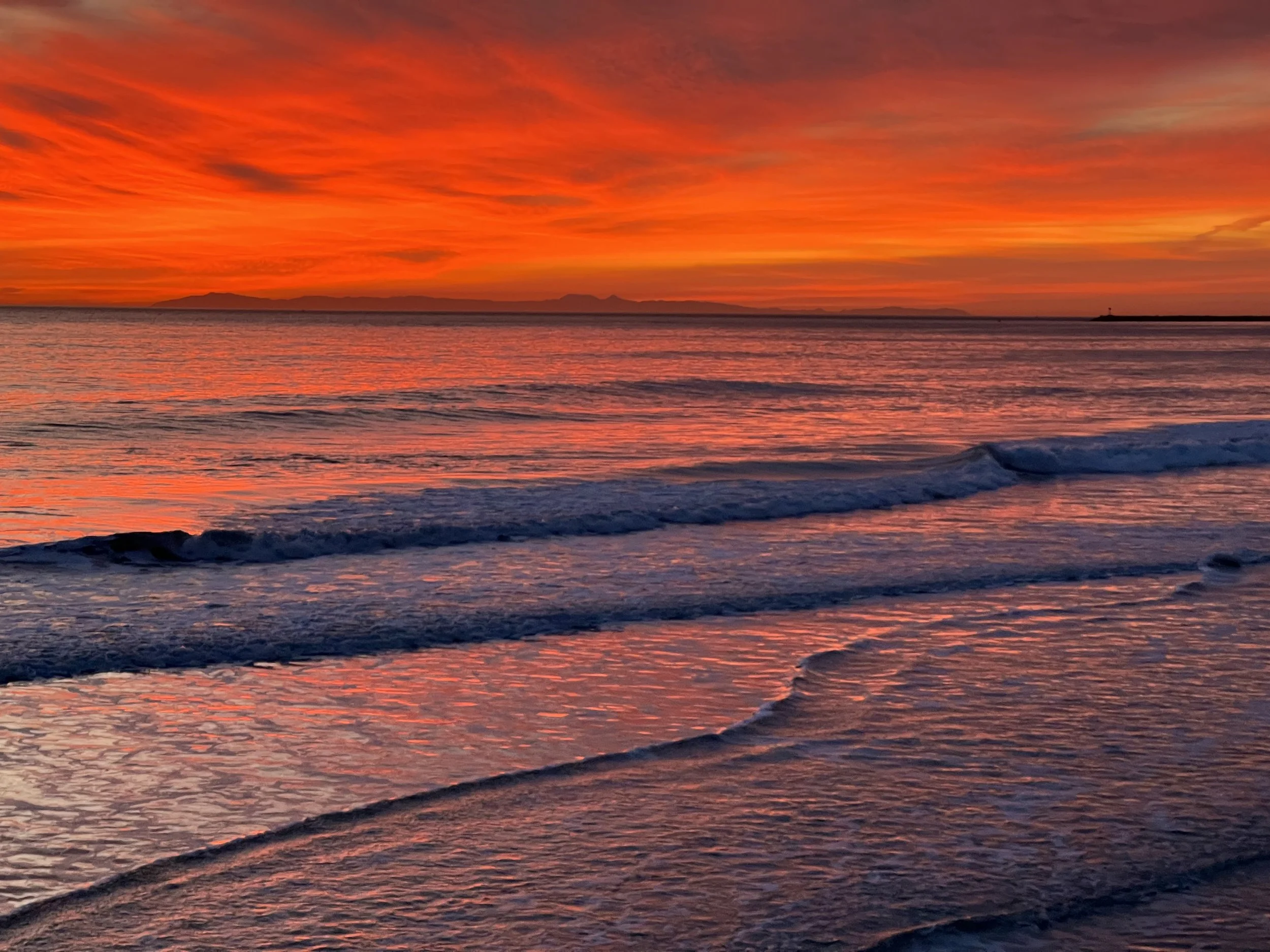 Vibrant orange sunset over ocean waves