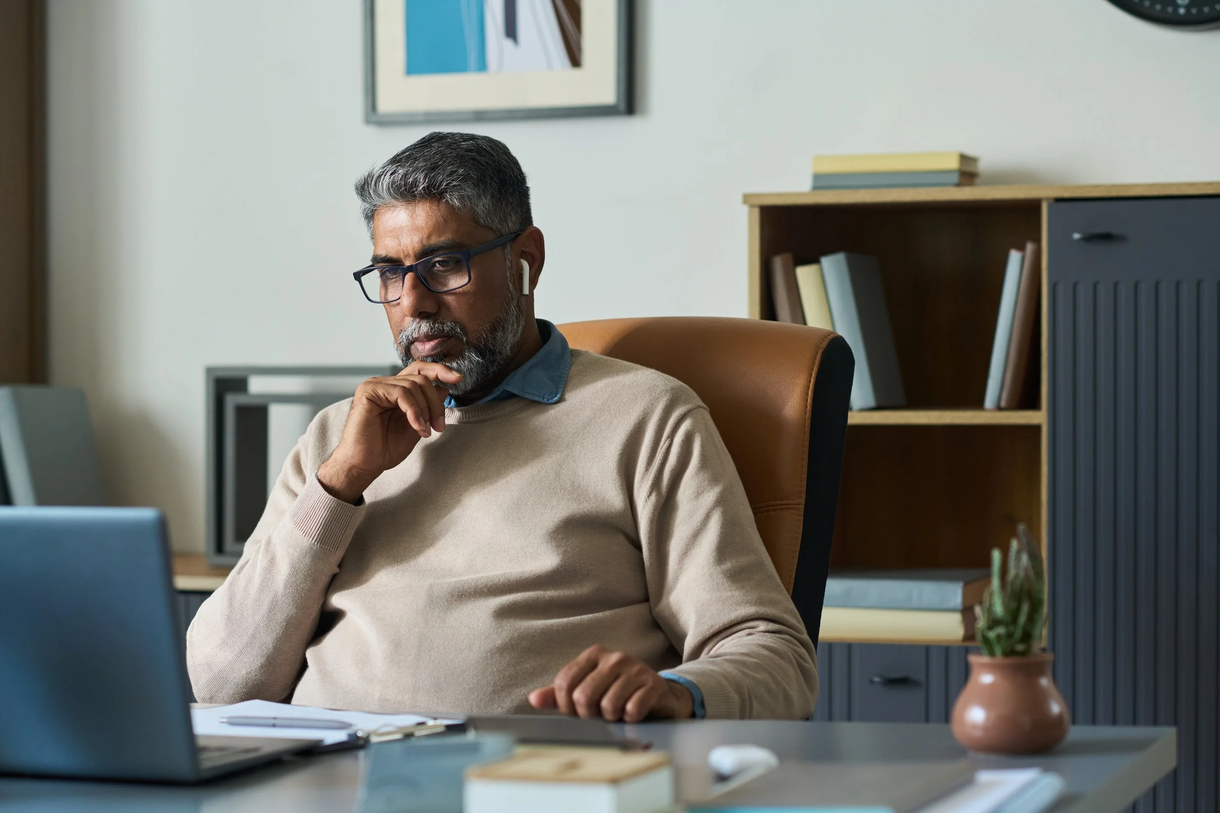 Man at desk on laptop. Early retirement from Oracle involves weighing RSU vesting schedules, Medicare gaps, and Social Security timing before you make the leap.