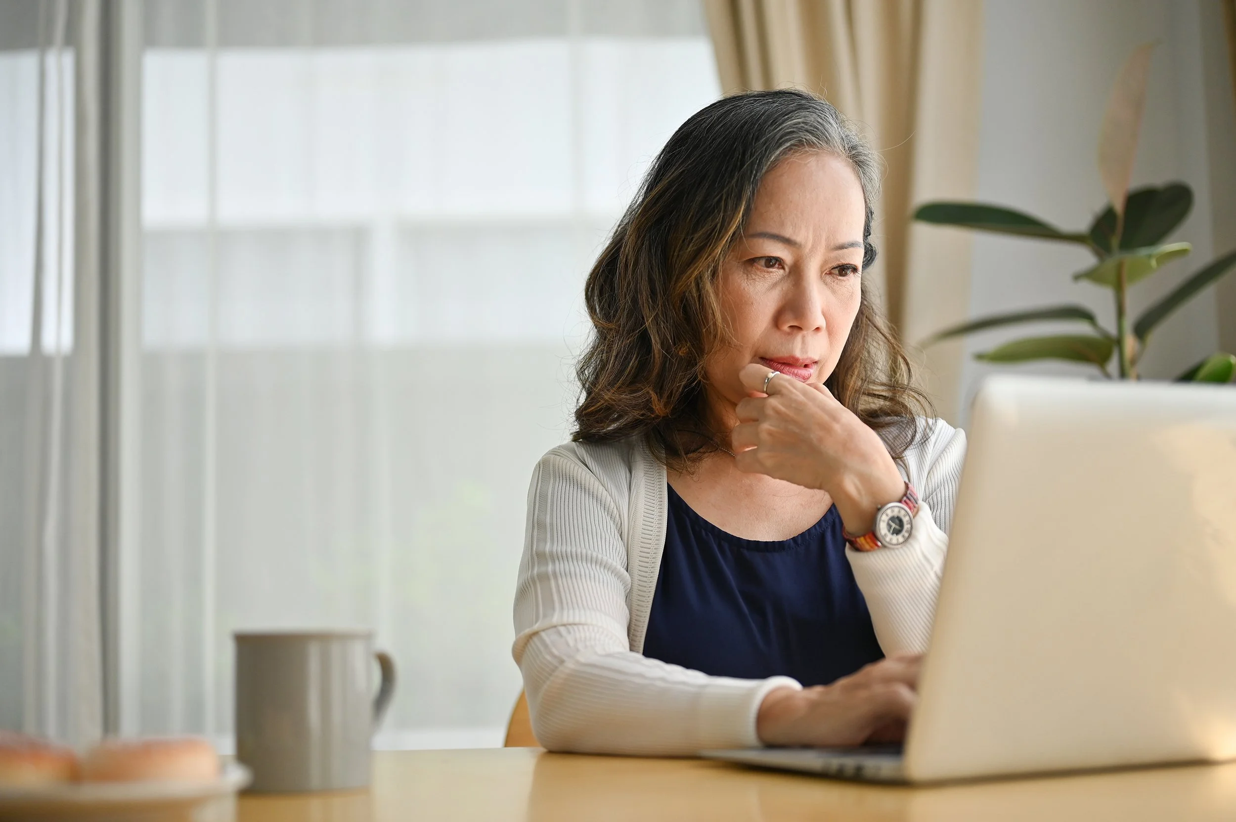 A middle-aged woman works on a computer. If you're a Google employee considering early retirement, the rule of 55 could be a game-changer for your financial strategy.