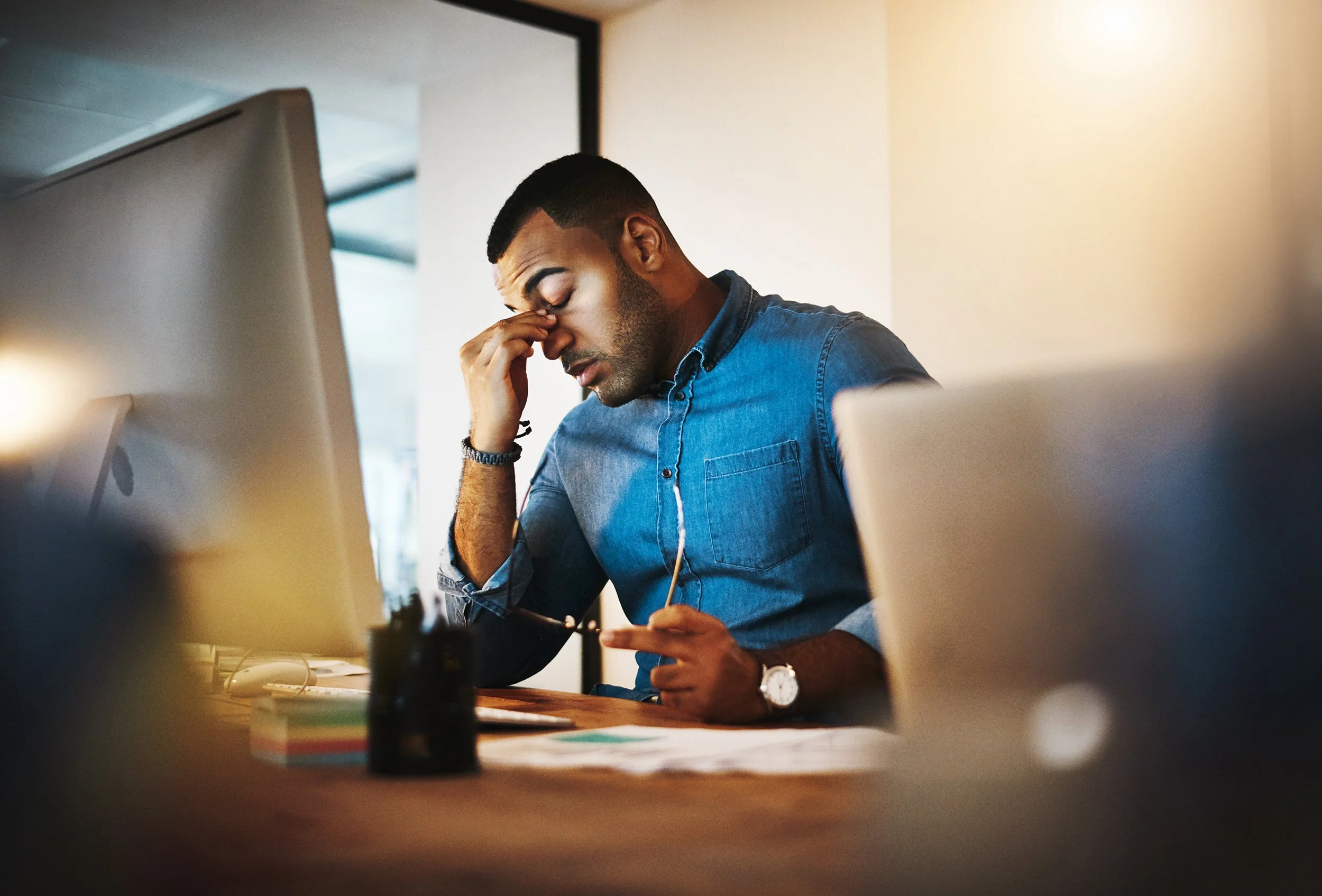 A man looking stressed at his computer. Cisco laid off 5% of its workforce. Here's what happens to your 401(k), RSUs, ESPP, HSA, and healthcare benefits.