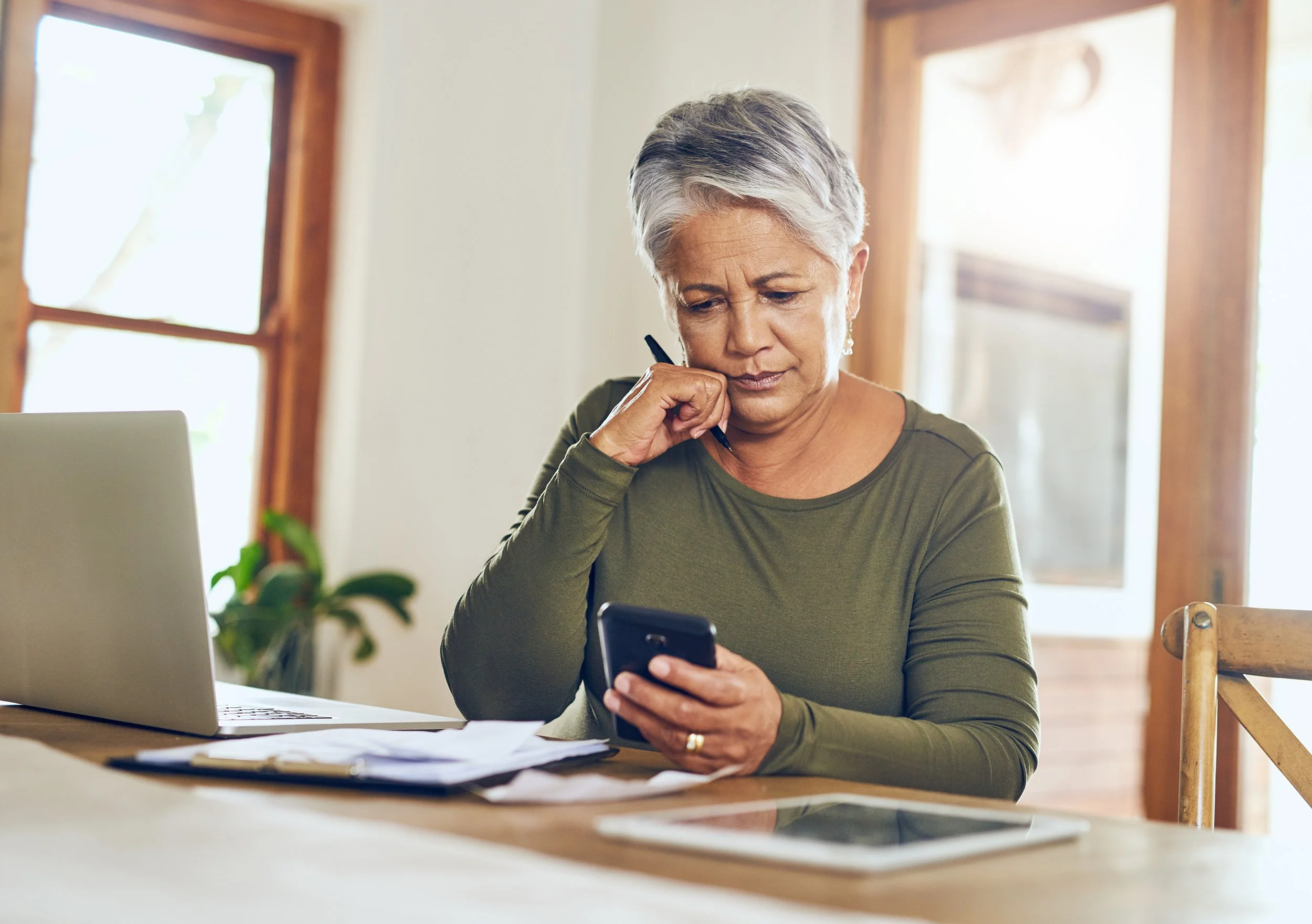A woman looks at her phone. Learn how Oracle's annual RSU vesting schedule and double taxation work so you can plan each vesting date instead of reacting to it.