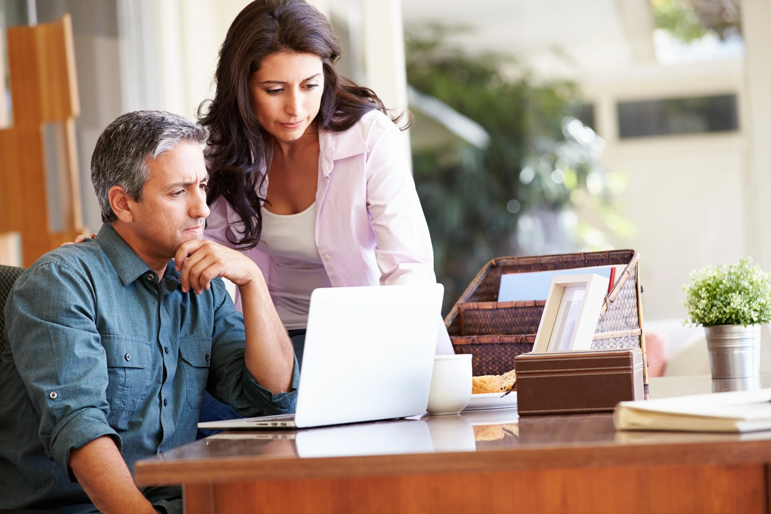 Couple at desk looking at laptop. OpenAI's IPO will trigger major tax events for employees. Learn what to expect with RSU vesting, lockups, and tax-efficient selling strategies.
