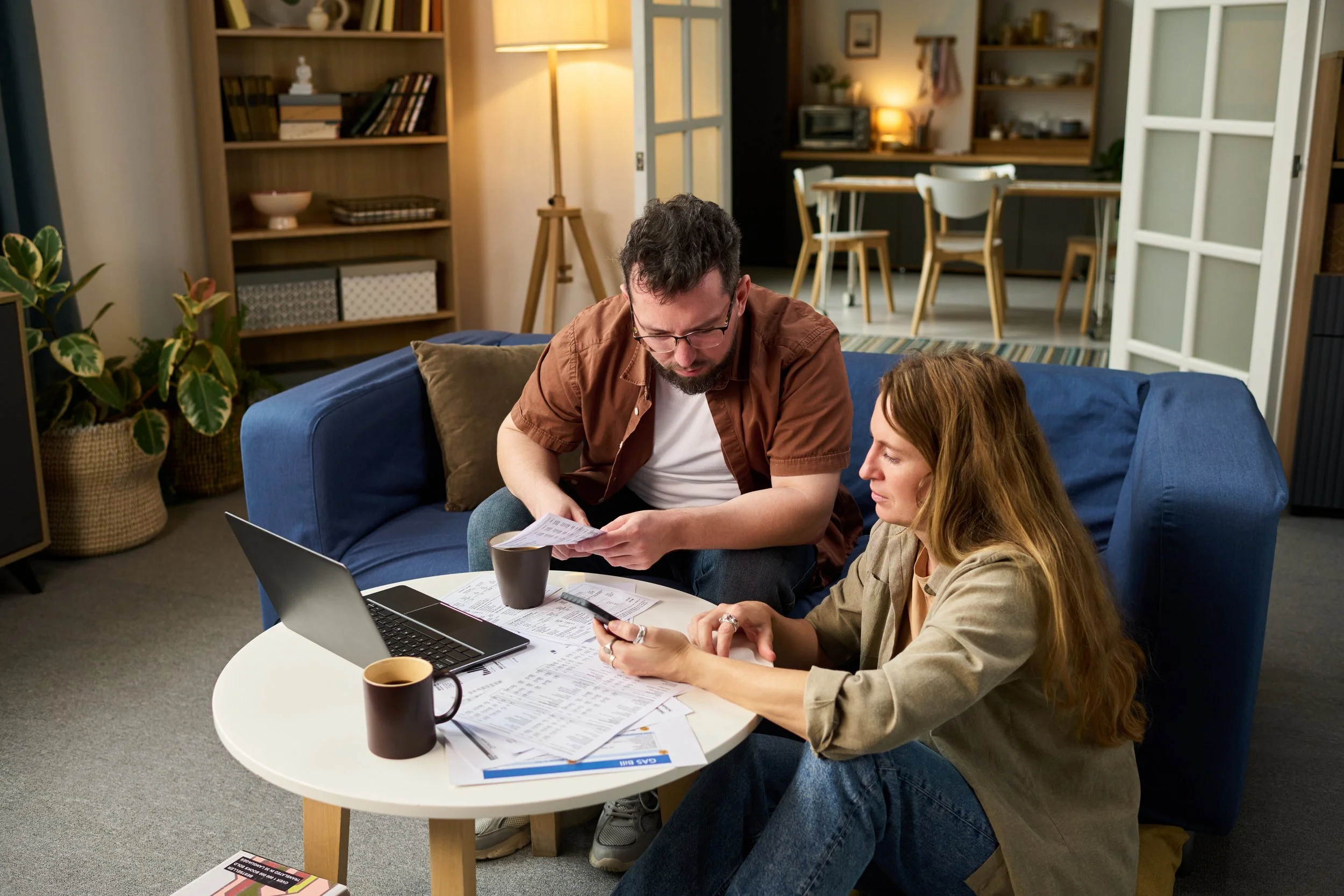 Couple at coffee table with laptop. Stripe employee? Get answers on IPO timing, RSU vesting, taxes, and selling strategies for your equity before and after a public listing.