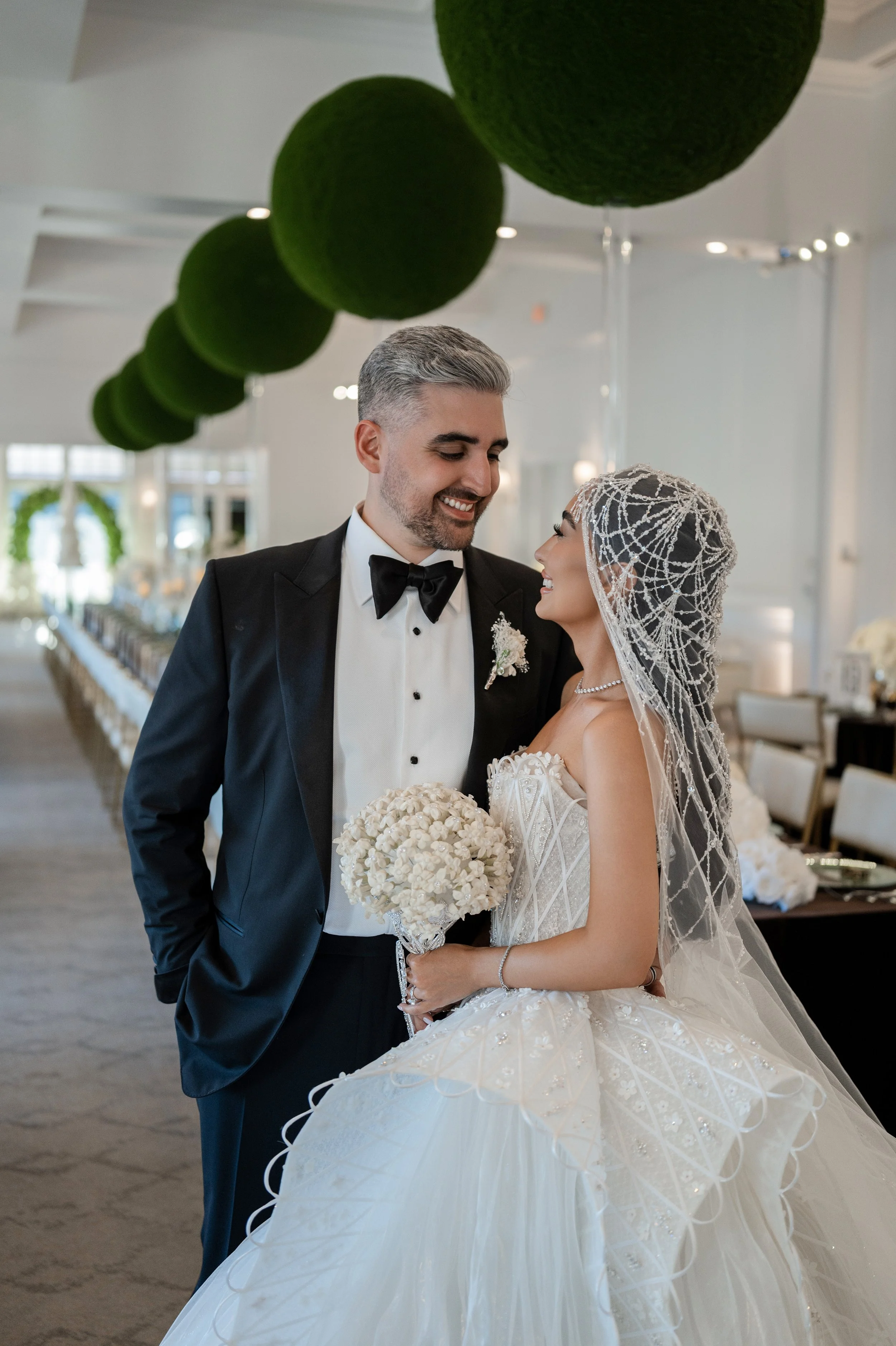 Bride and groom in a gorgeous ballroom with jimmy choo gown.