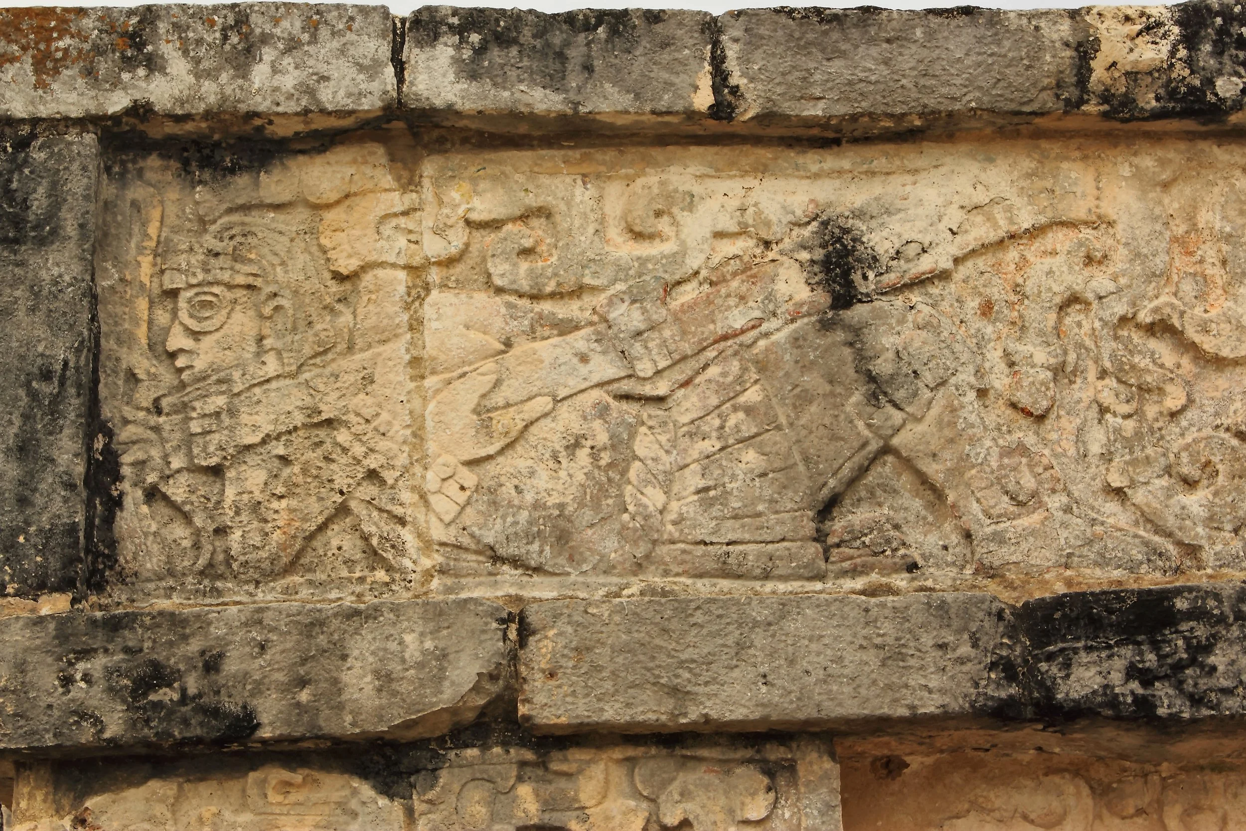 Close-up view of a stone wall with aged, weathered bricks featuring ancient carvings or inscriptions.