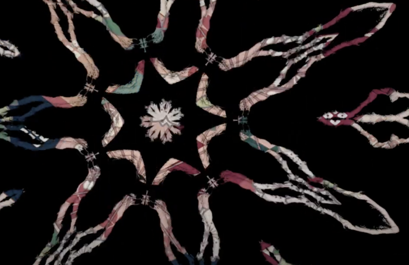 A colorful kaleidoscope pattern with pink, green, blue, and white shapes radiating from the center against a black background.