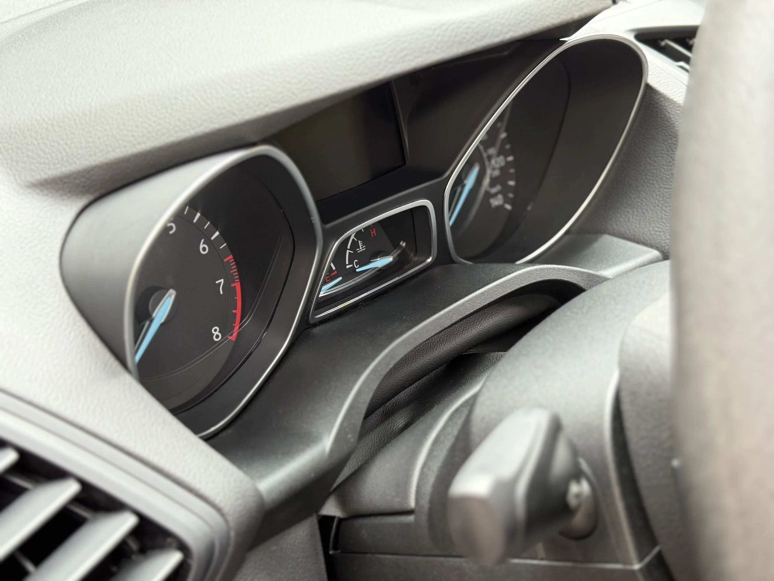 Close-up of a car's instrument cluster displaying the speedometer, tachometer, and fuel gauge.