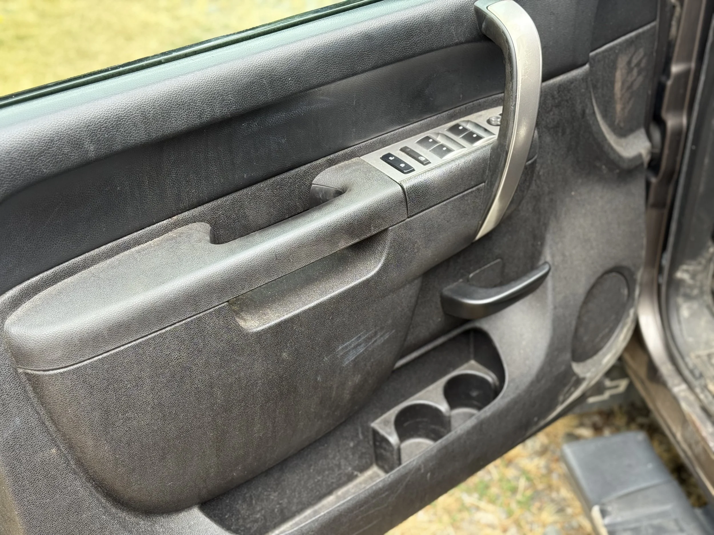 Close-up of the interior of a car door, showing the window controls, door handle, and storage compartments.